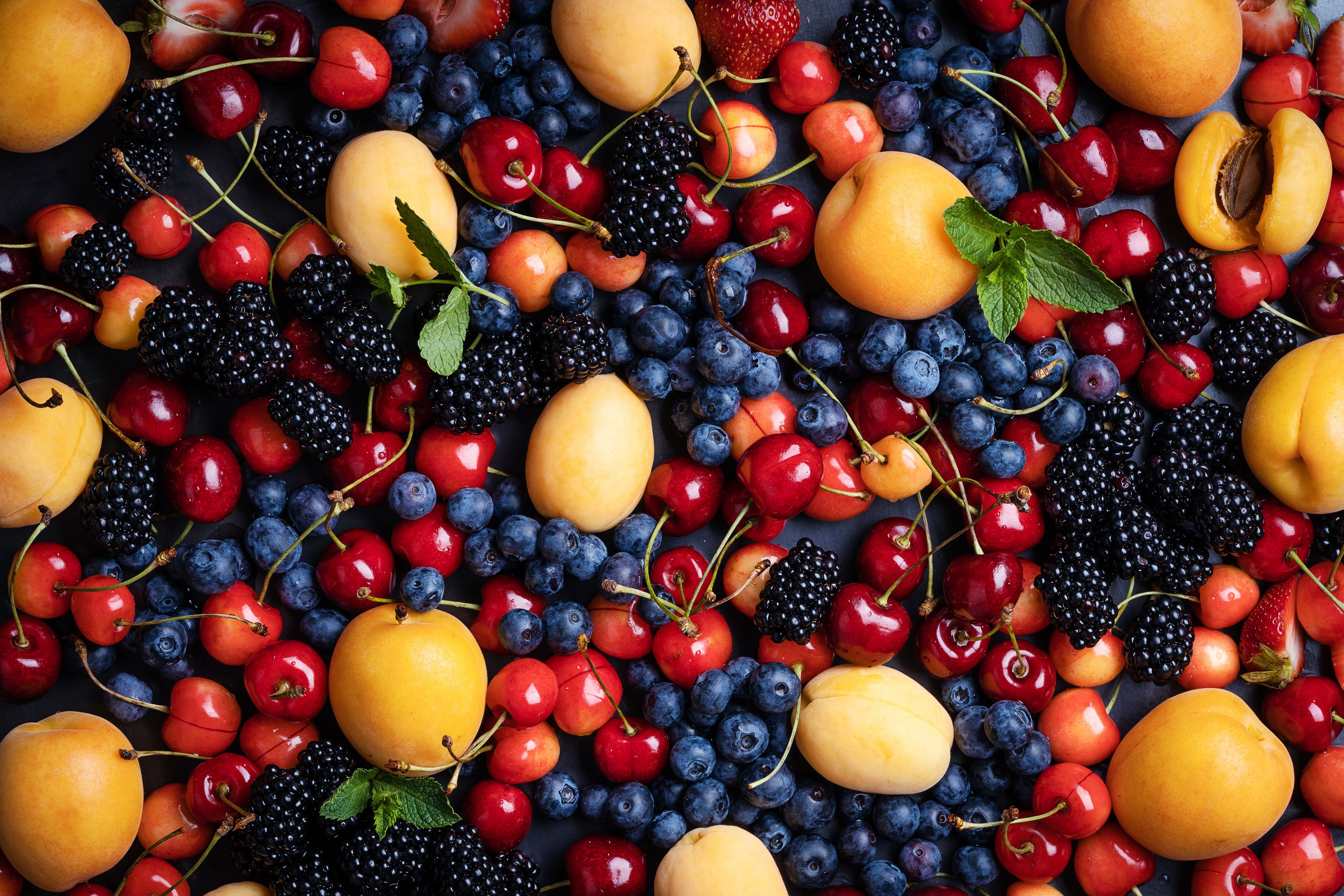 Verschiedene Sommerfrüchte wie Kirschen, Aprikosen, Brombeeren und Blaubeeren bunt gemischt.