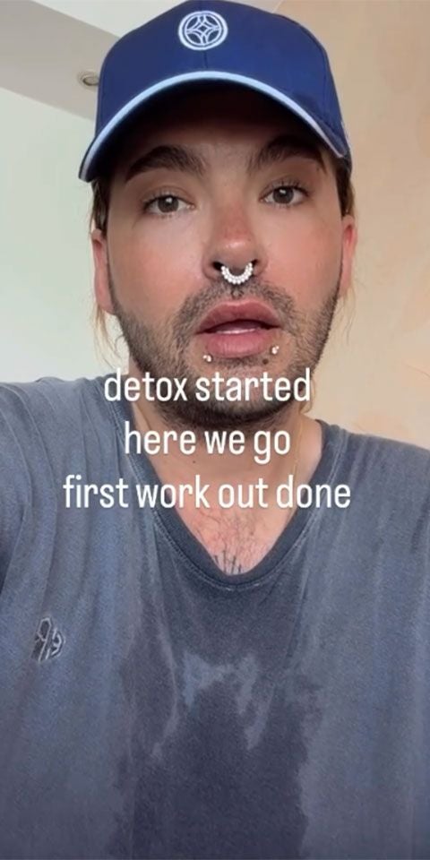 Verschwitze Person mit Piercings und Cap nach dem Training, Text: "detox started here we go first work out done".