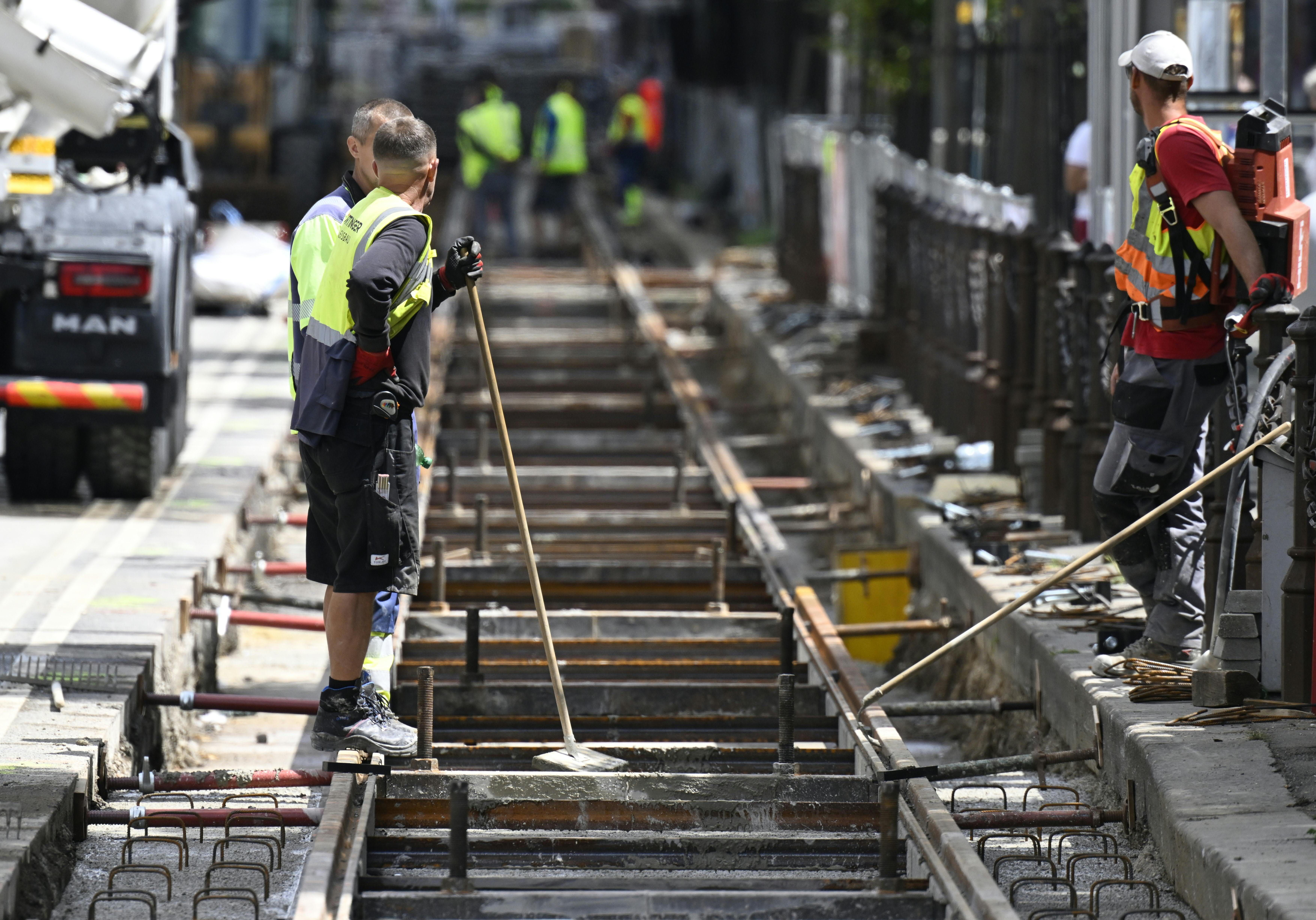 Bauarbeiter arbeiten an einer Straßenbahn-Gleisbaustelle auf der Wiener Ringstraße.