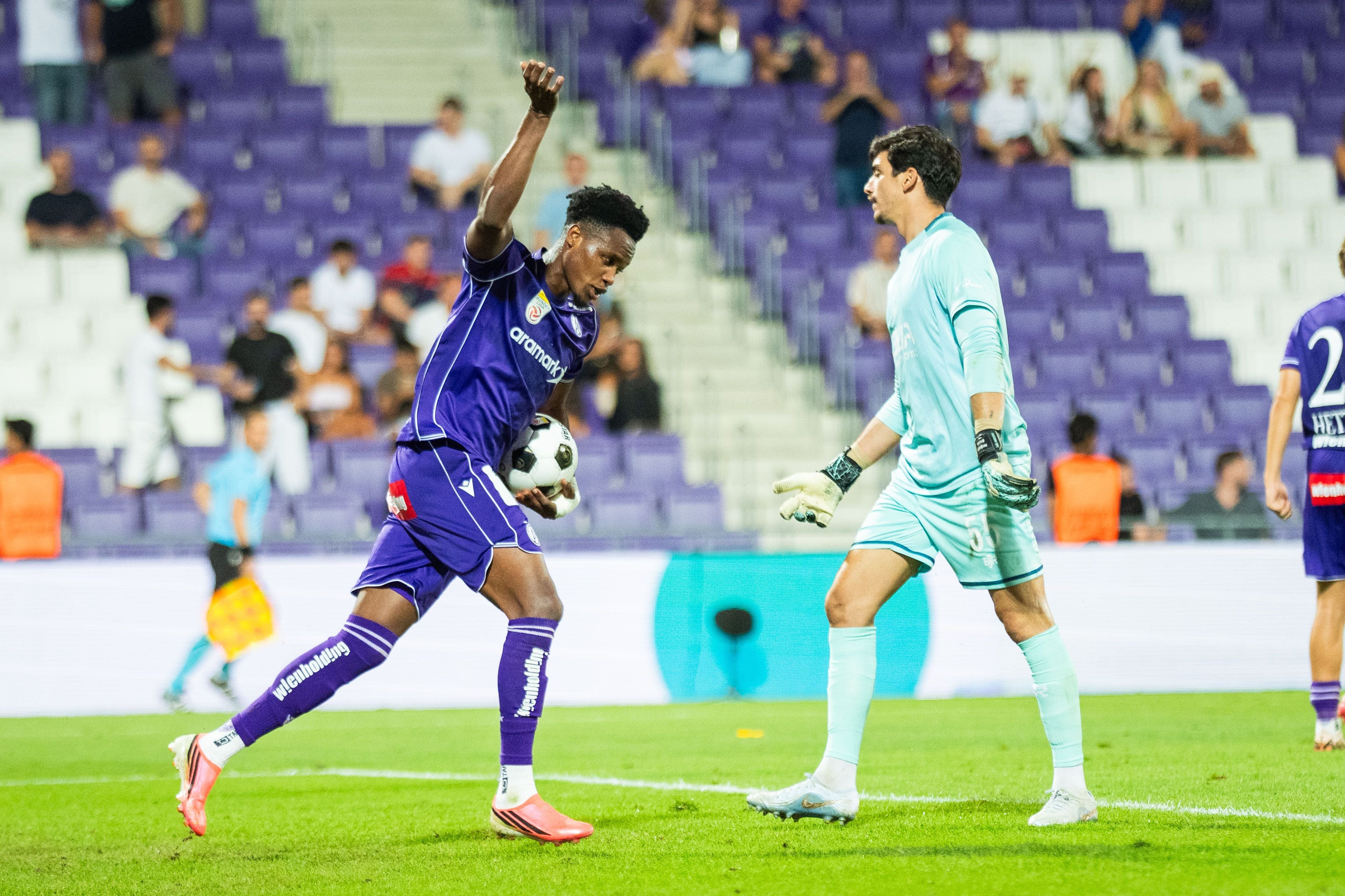 Ein Fußballspieler von Austria Wien jubelt nach einem Tor, daneben steht ein Torwart in hellblau.