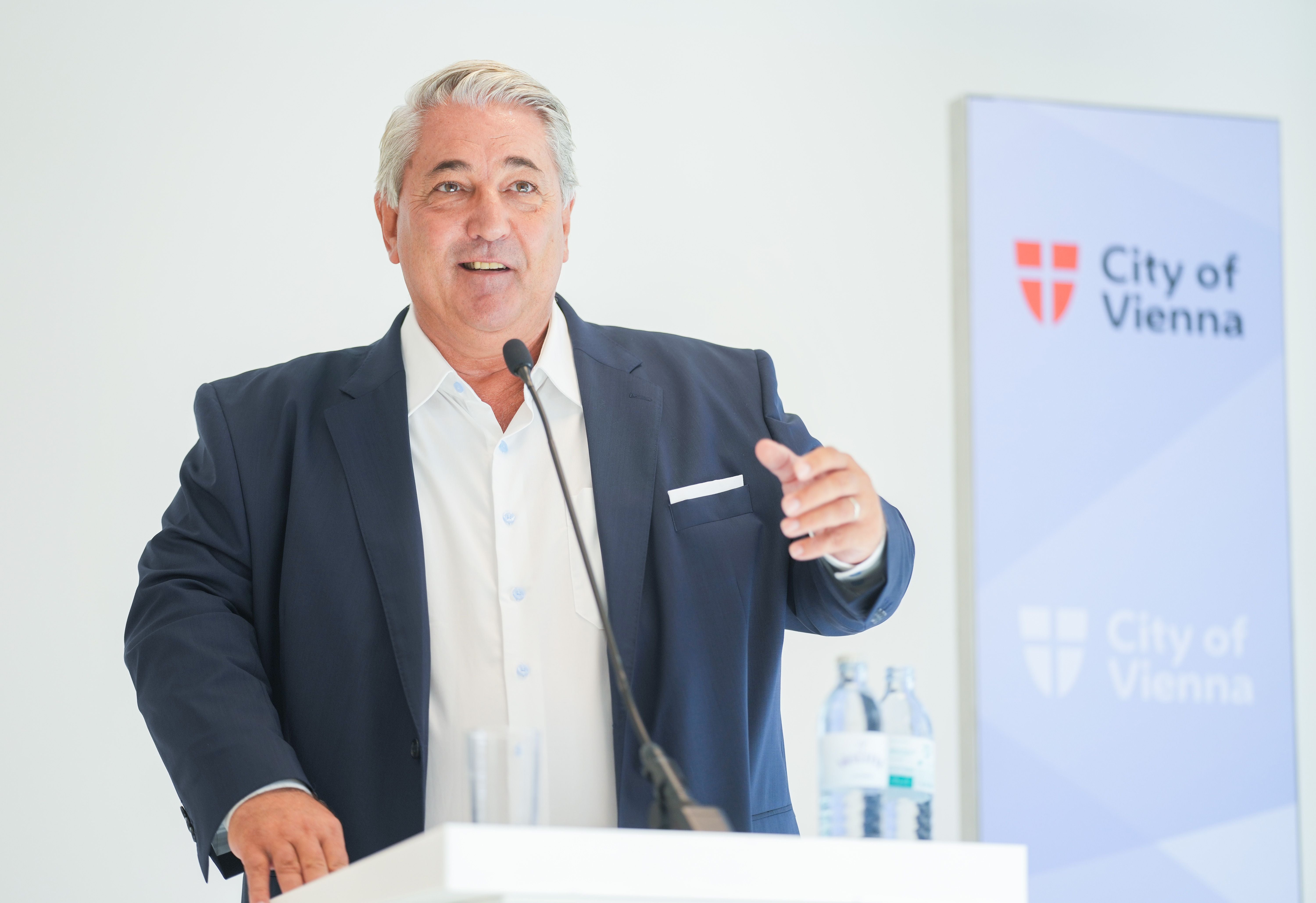 Ein Mann spricht am Rednerpult bei einer Pressekonferenz der Stadt Wien, im Hintergrund ein City of Vienna-Logo.