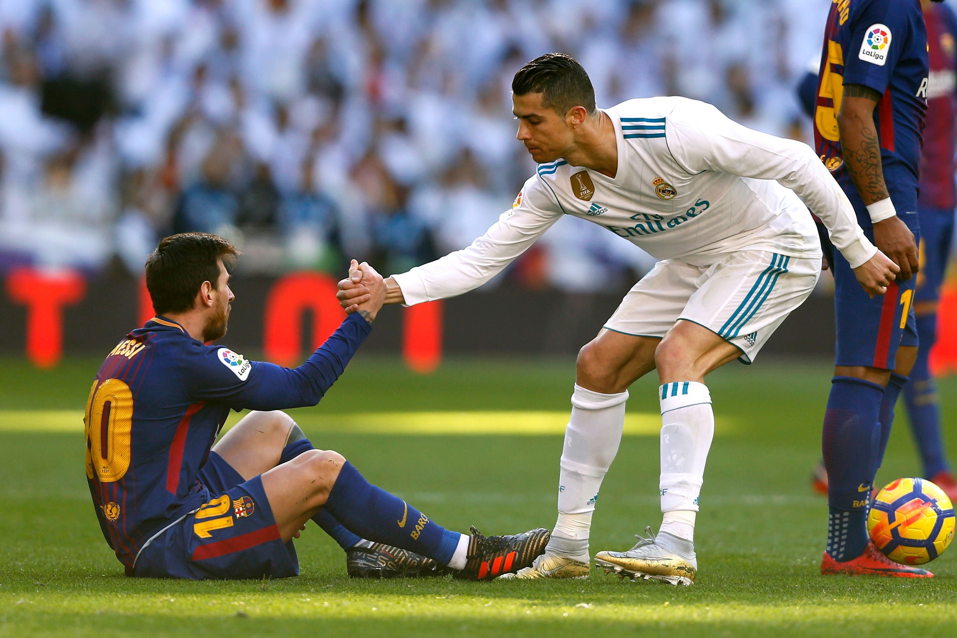 Cristiano Ronaldo hilft Lionel Messi beim Aufstehen während eines Fußballspiels.