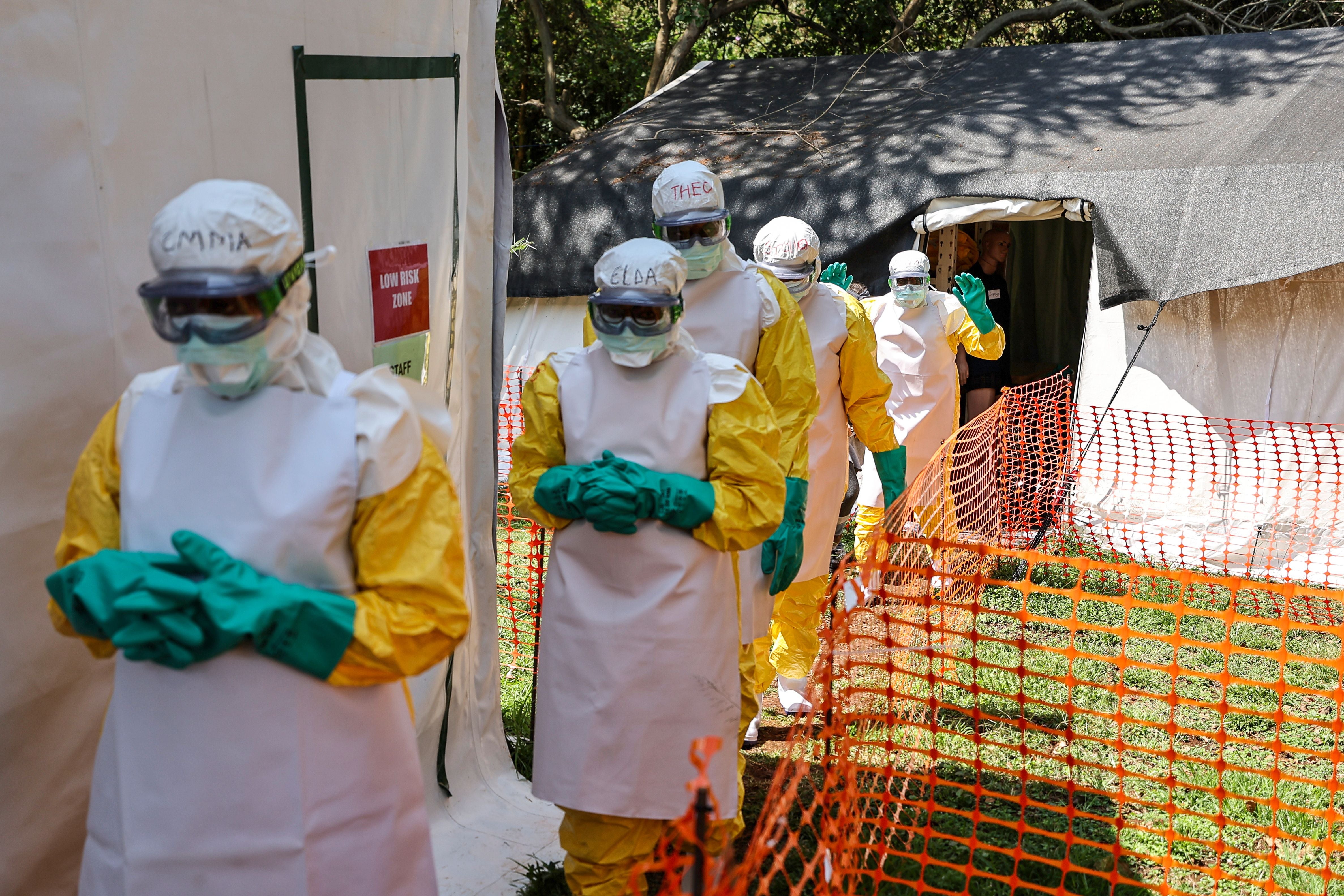Freiwillige Gesundheitspersonal in Schutzanzügen bei Ebola-Notfalltraining im Freien.