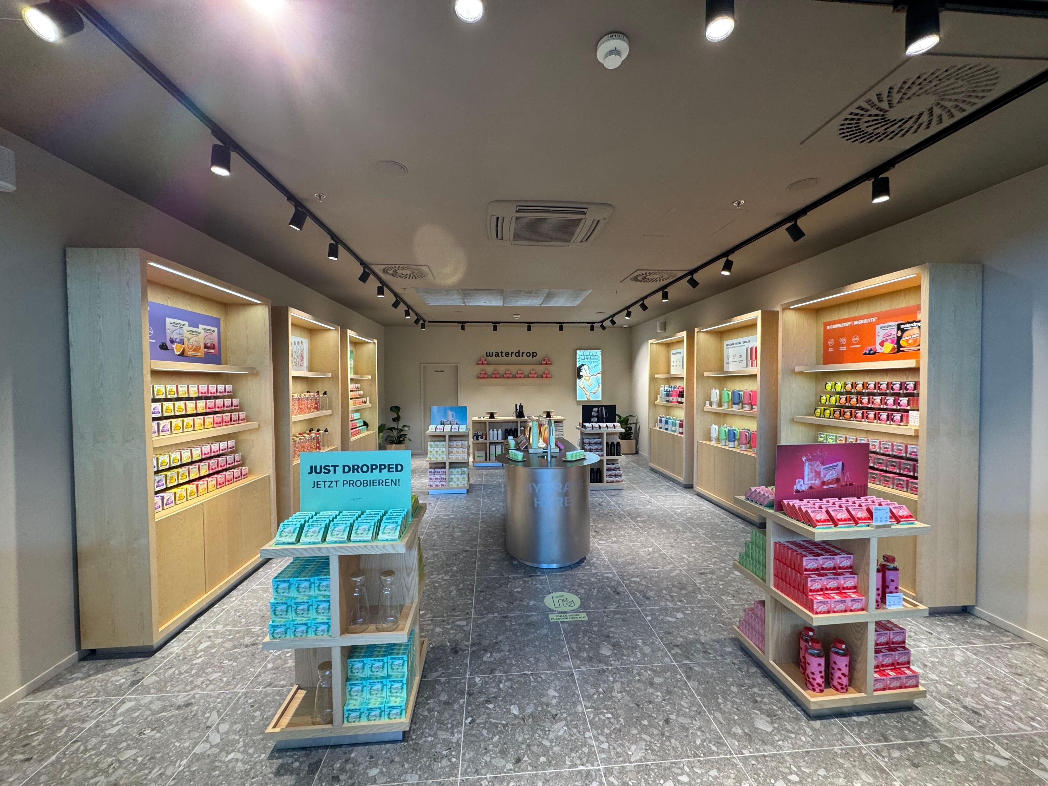 Moderner Waterdrop-Store mit bunten Produkten und stilvoller Präsentation im Donauzentrum.