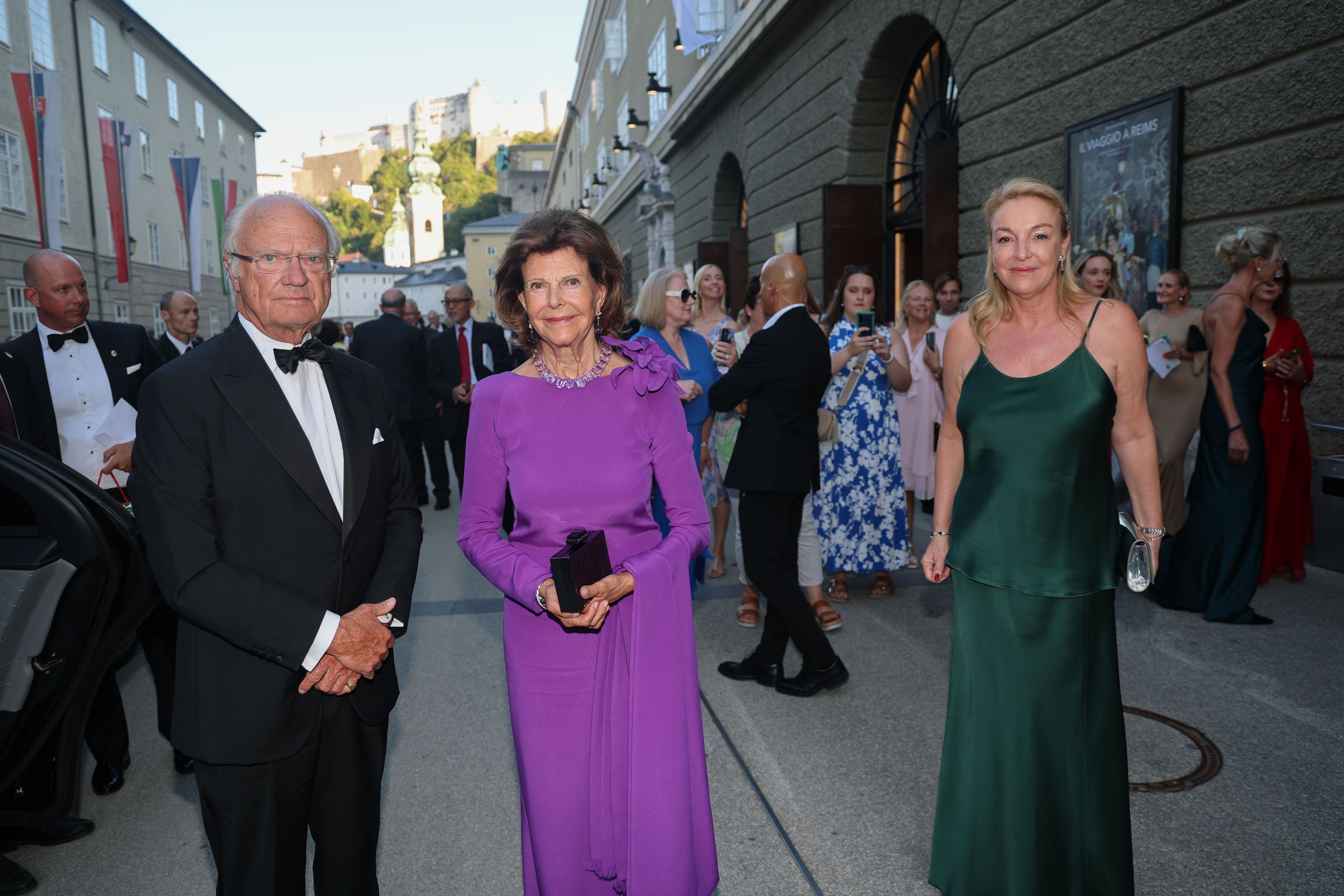 Königspaar aus Schweden und eine Frau in Abendkleidung vor dem Festspielhaus bei den Salzburger Festspielen.