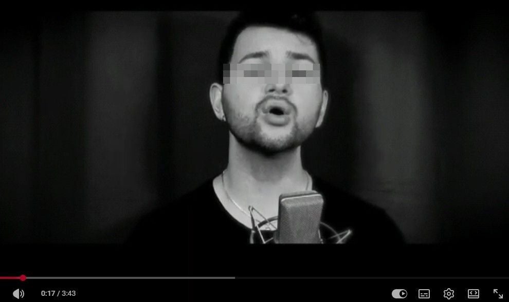 Schwarzweißbild eines singenden Mannes vor einem Mikrofon, das Gesicht ist verpixelt. In