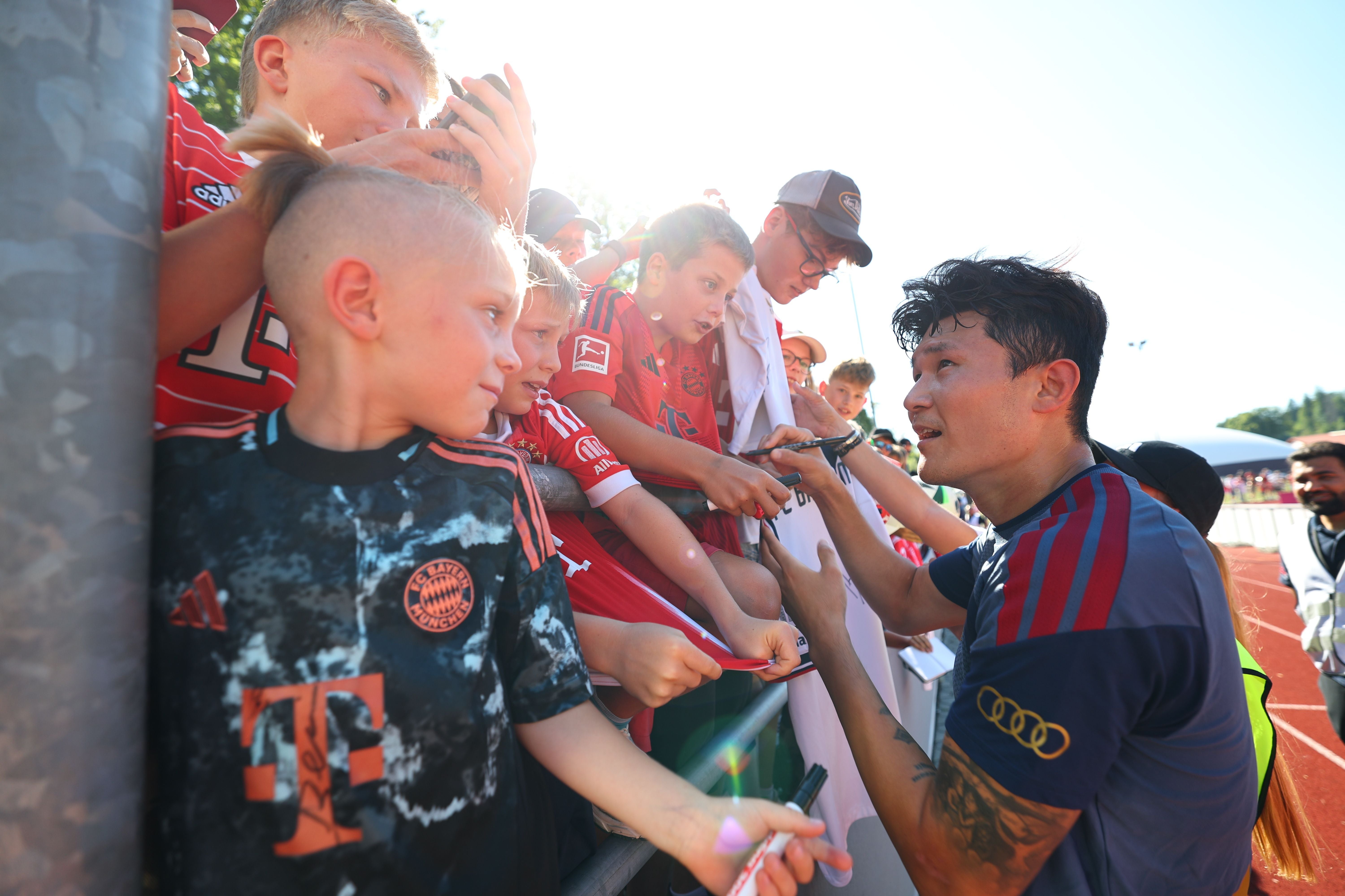 Minjae Kim gibt bei einer Trainingseinheit in Rottach-Egern Autogramme an junge Fans.