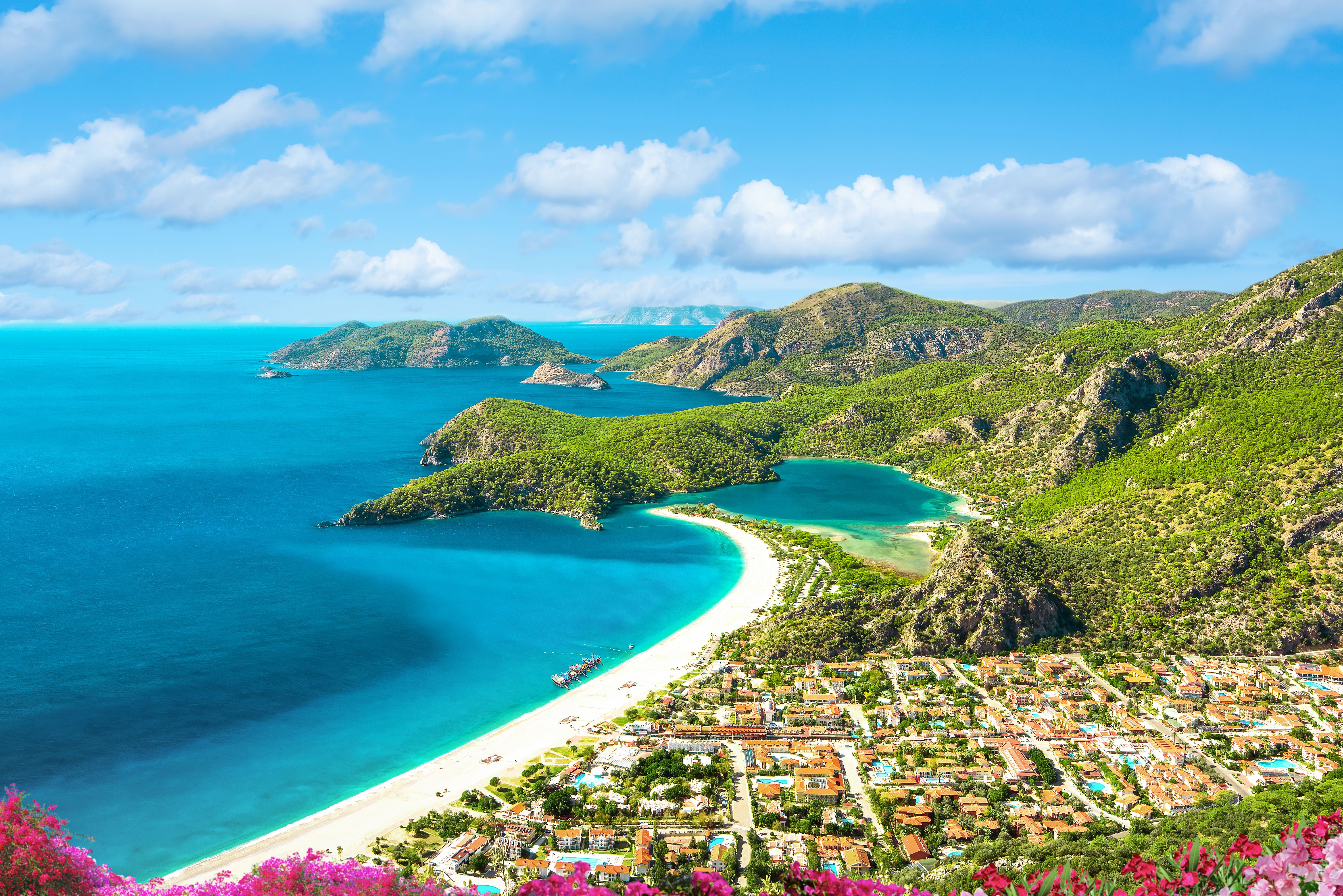 Panorama der berühmten Blauen Lagune von Ölüdeniz in der Türkei mit Strand und grünen Hügeln.