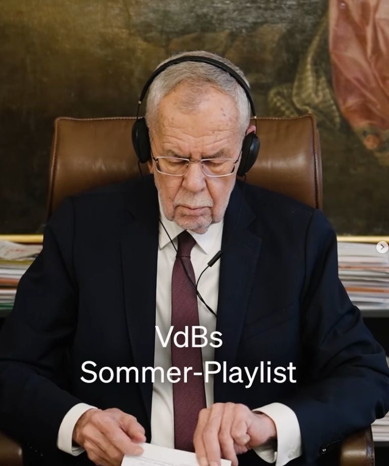 Älterer Mann mit Kopfhörern sitzt im Anzug am Schreibtisch, Text: "VdBs Sommer-Playlist".