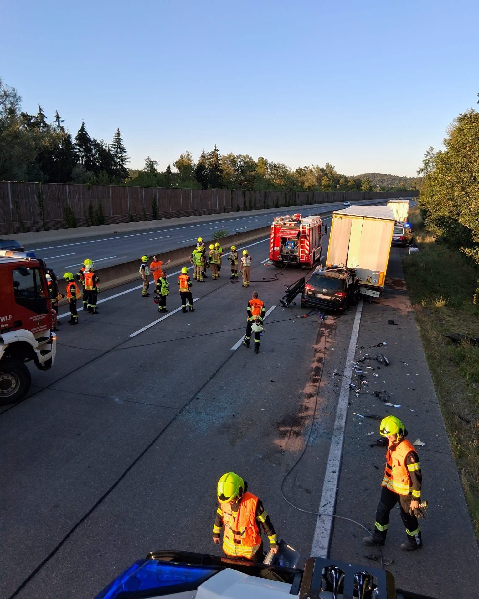 Feuerwehr und Rettungsdienst sichern Unfallstelle mit Lkw und Auto auf Autobahn bei Raaba ab.