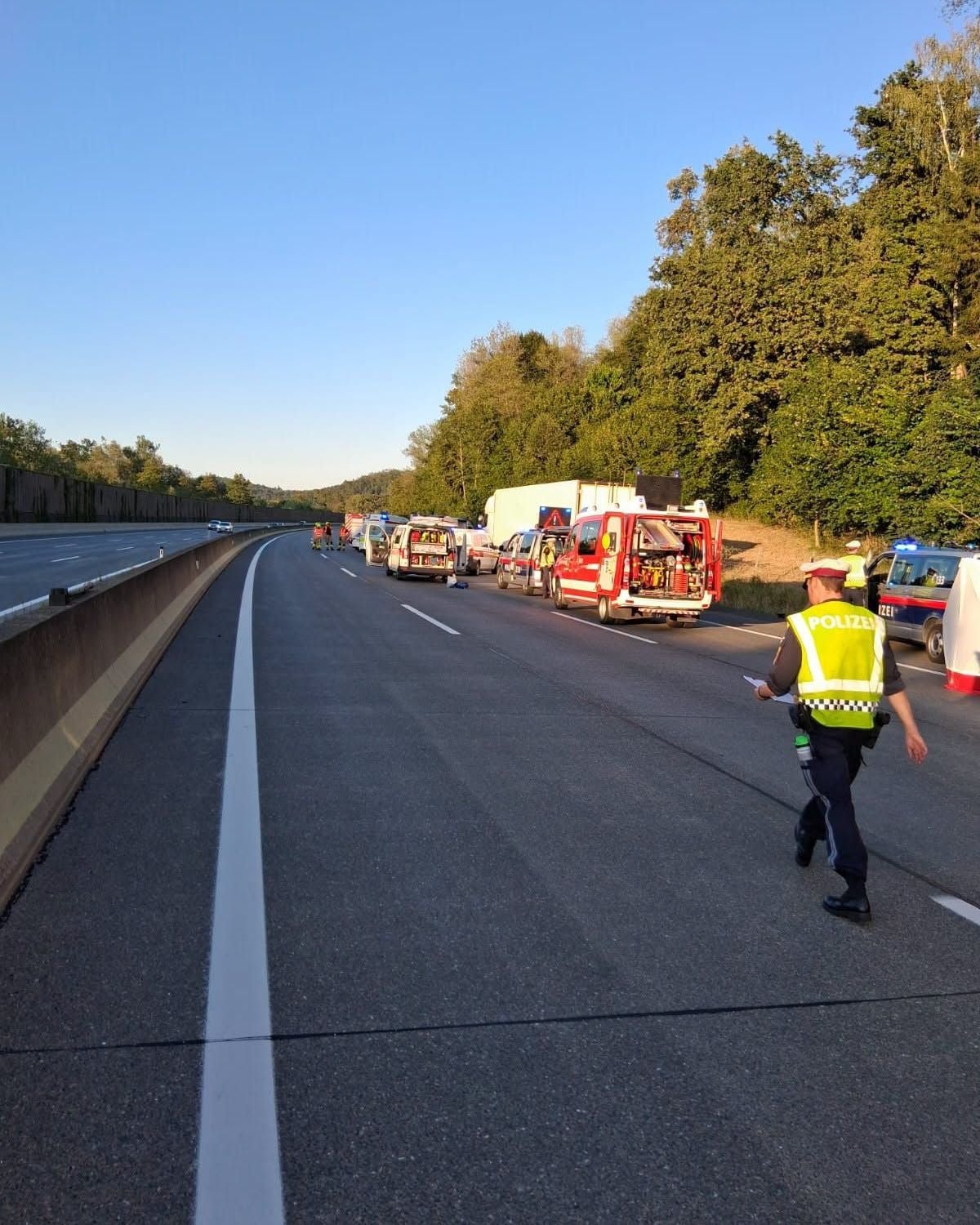 Polizei und Einsatzfahrzeuge stehen nach einem Unfall auf einer Autobahn bei Raaba.