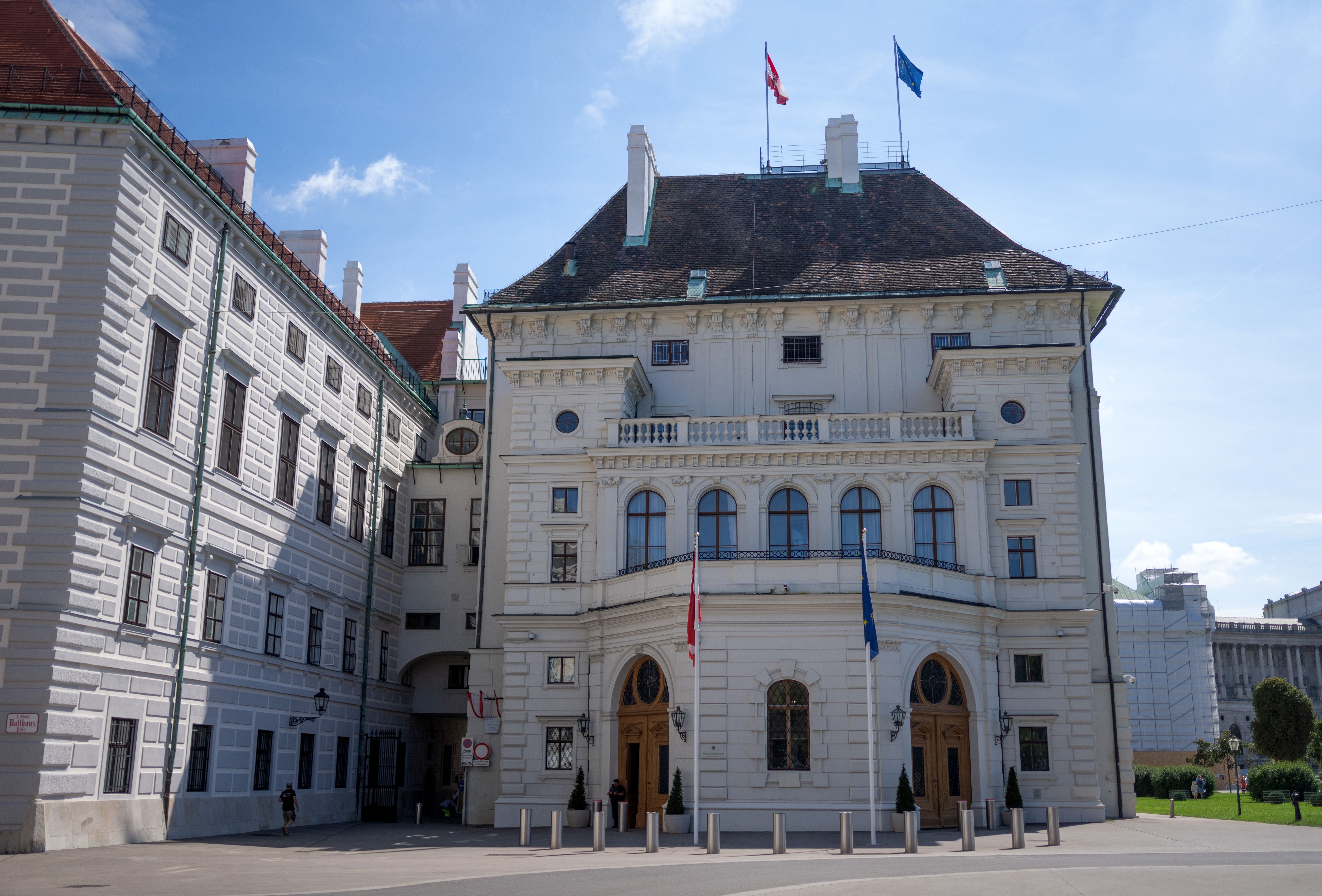 Außenansicht der Präsidentschaftskanzlei im Leopoldinischen Trakt der Wiener Hofburg bei Sonnenschein.