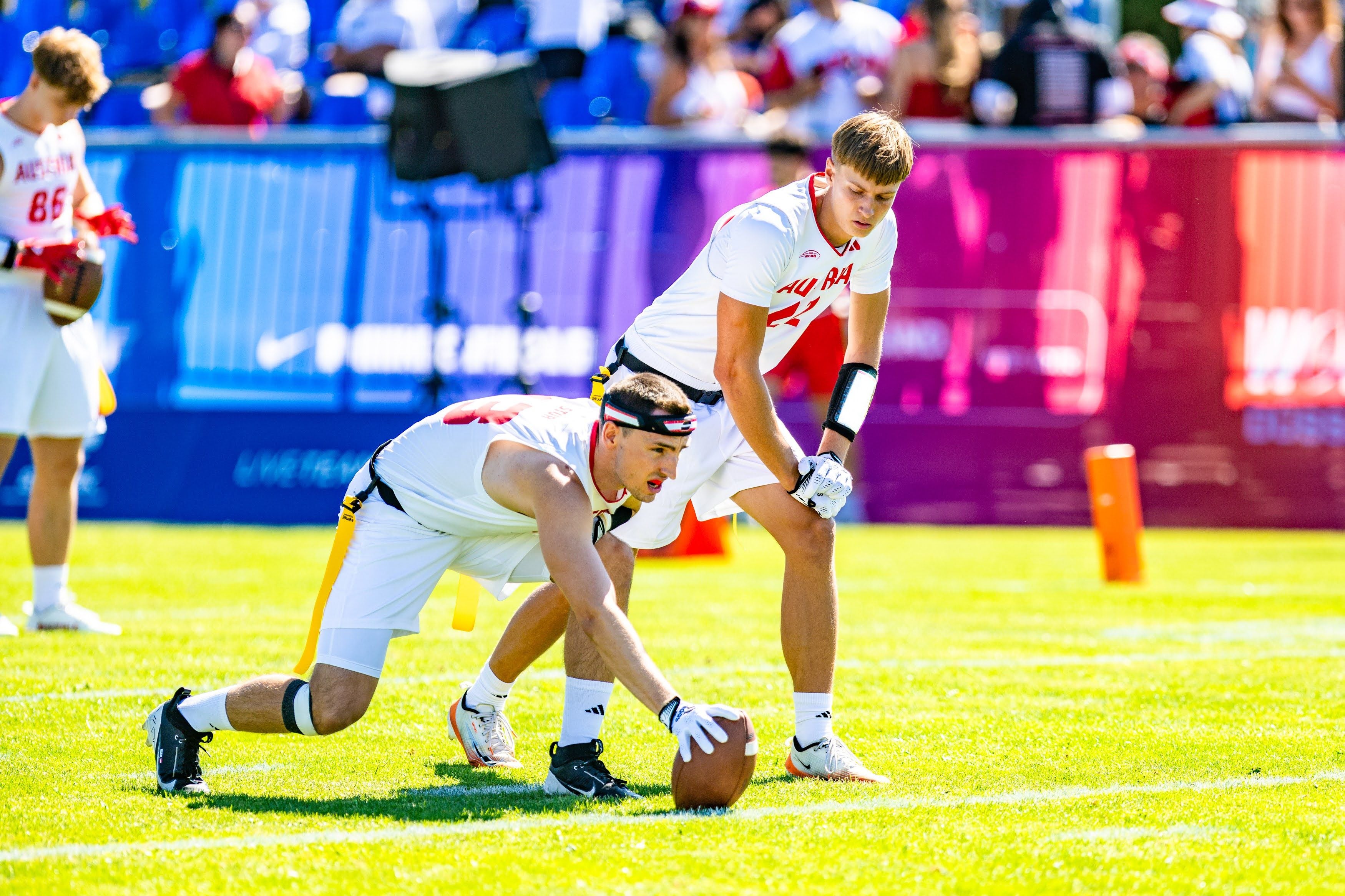 Zwei Flag Football-Spieler aus Österreich bereiten einen Spielzug auf dem Feld vor.