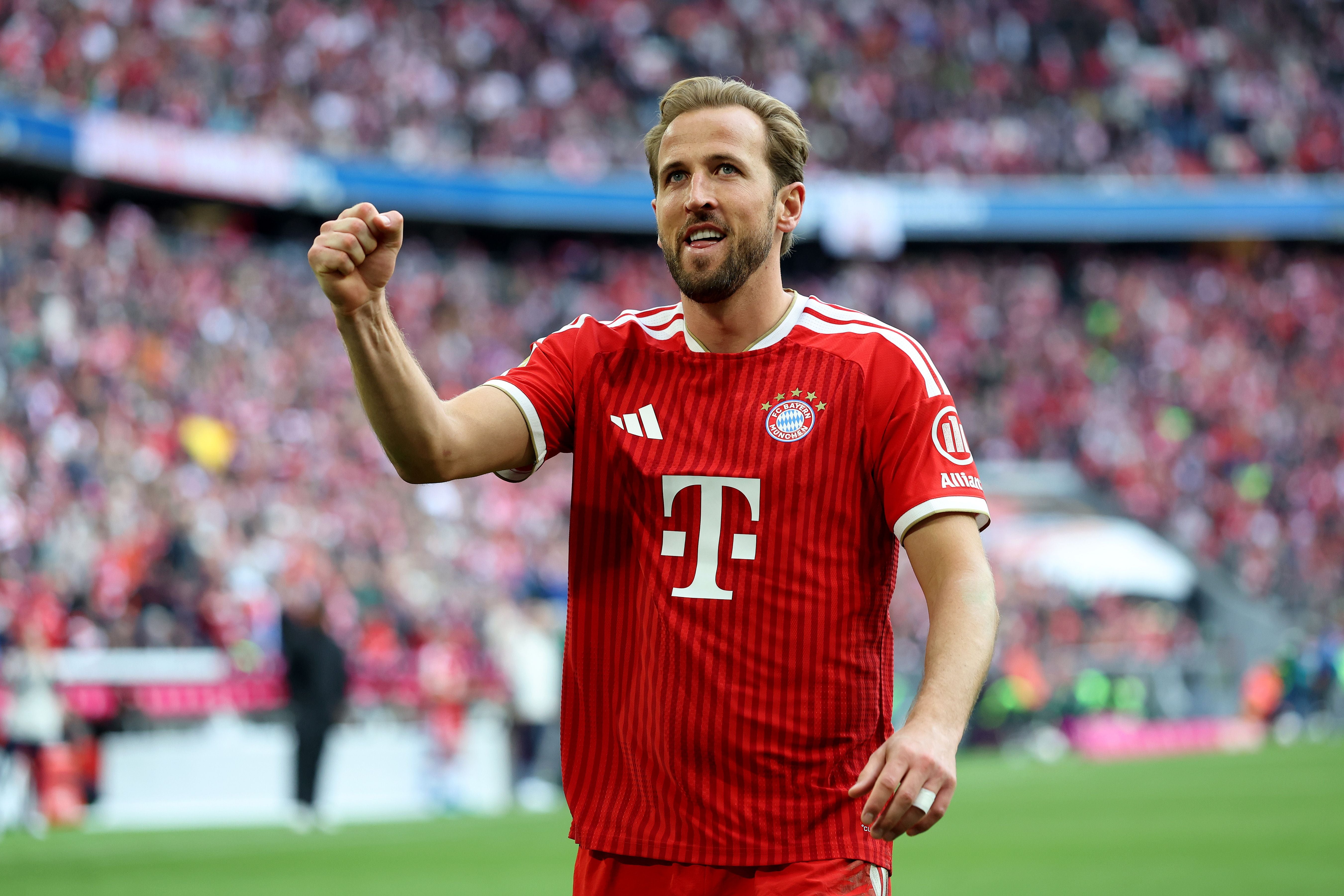 Ein Bayern-Spieler jubelt im Stadion nach einem Tor, Fans im Hintergrund.