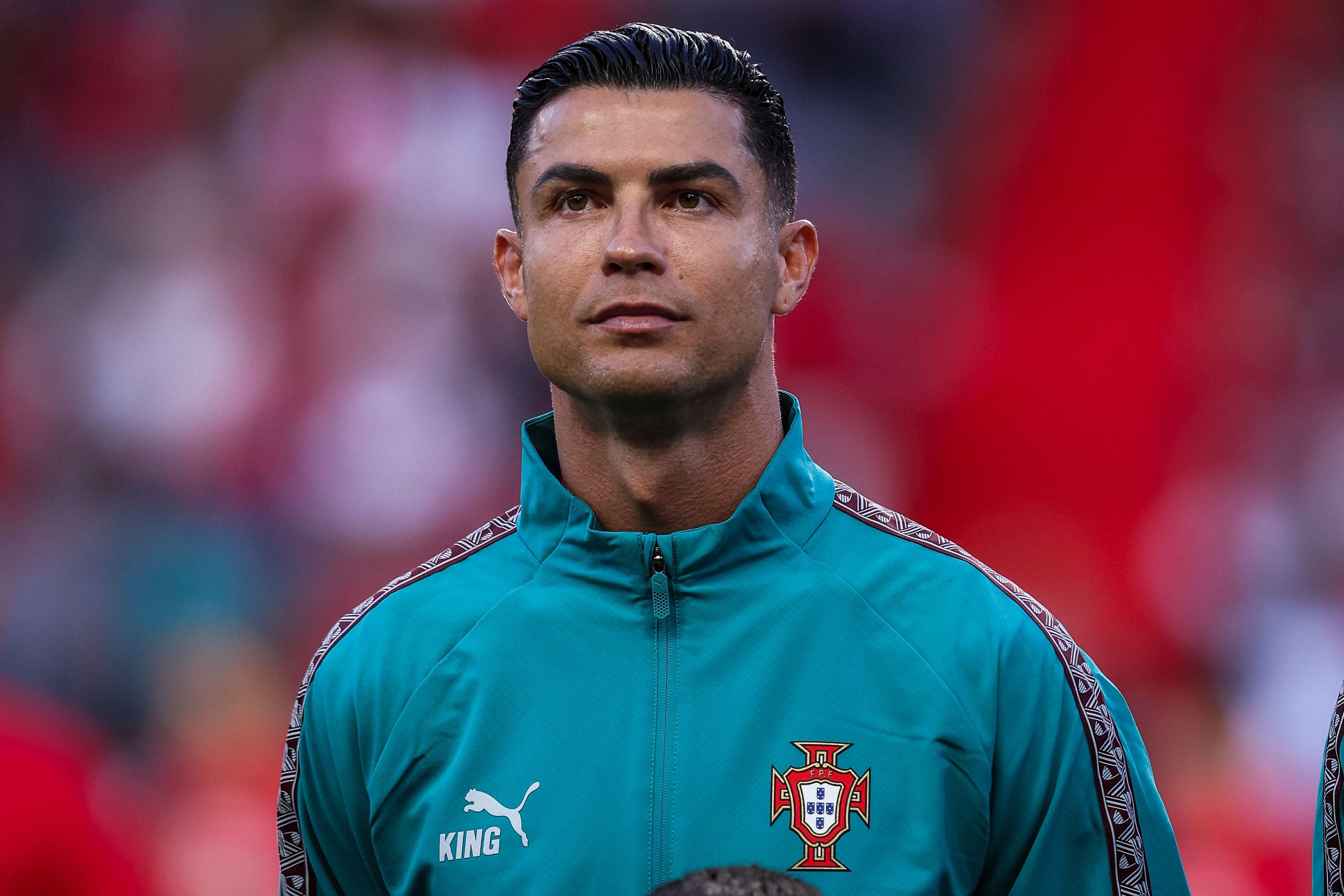 Ein Fußballspieler im türkisfarbenen Portugal-Trainingsanzug steht im Stadion.