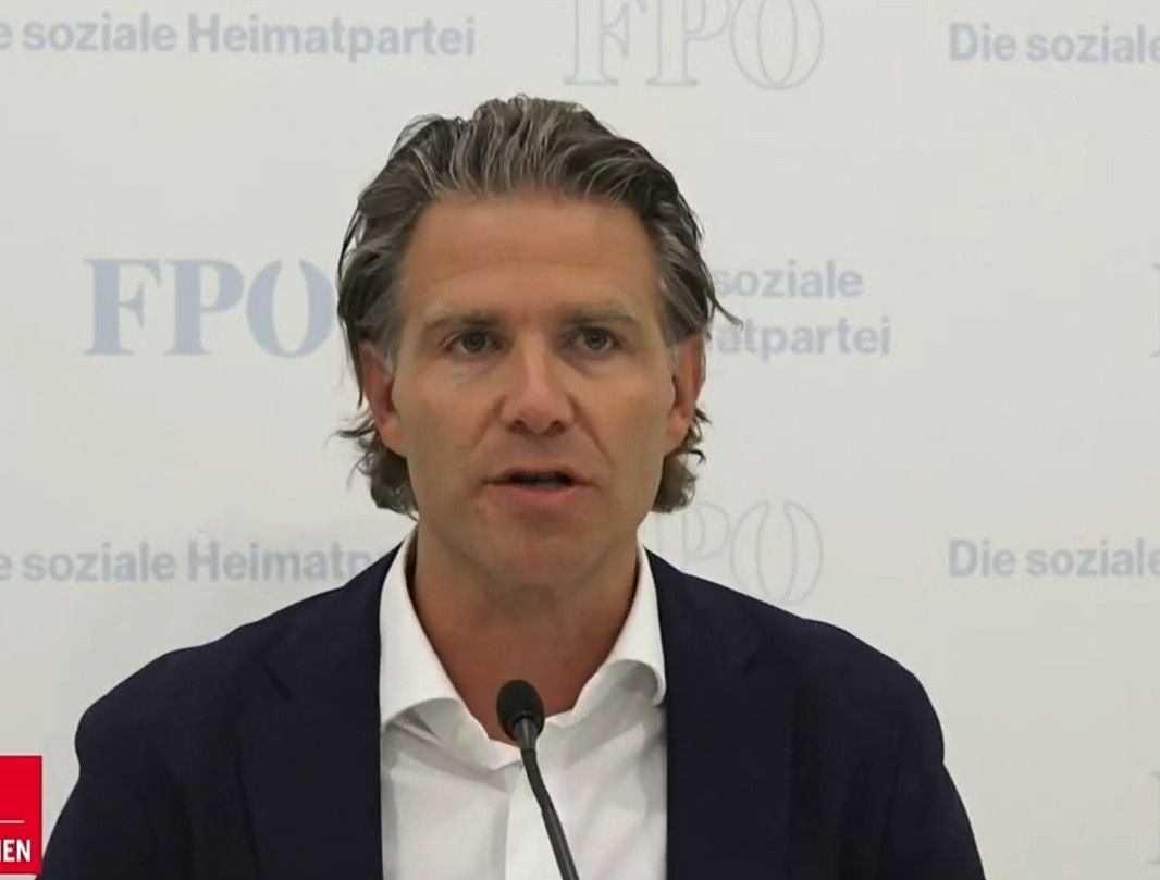 Ein Mann spricht bei einer Pressekonferenz vor einer Wand mit FPÖ-Logos und Schriftzügen.