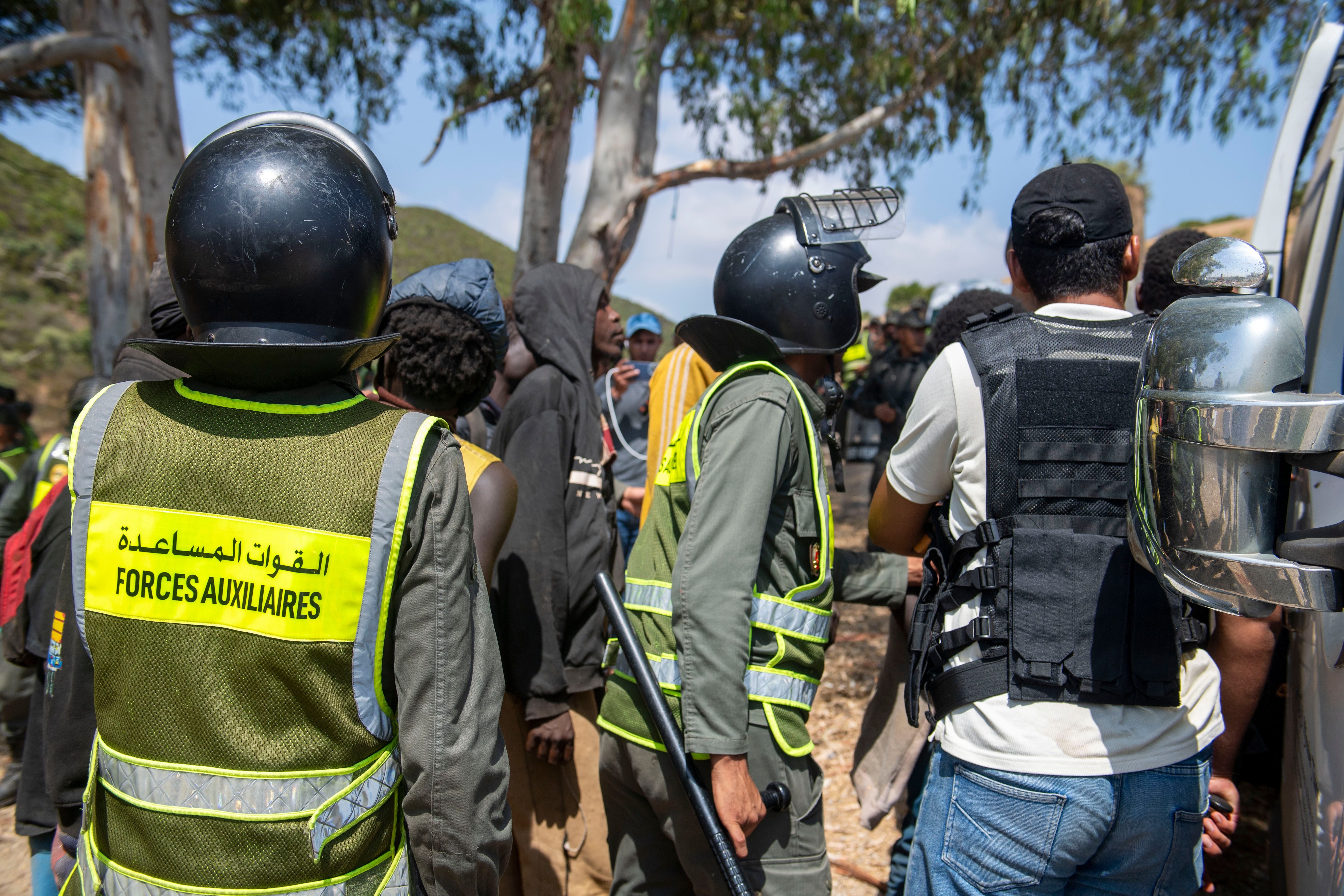 Marokkanische Sicherheitskräfte stoppen und kontrollieren eine Gruppe von Migranten.