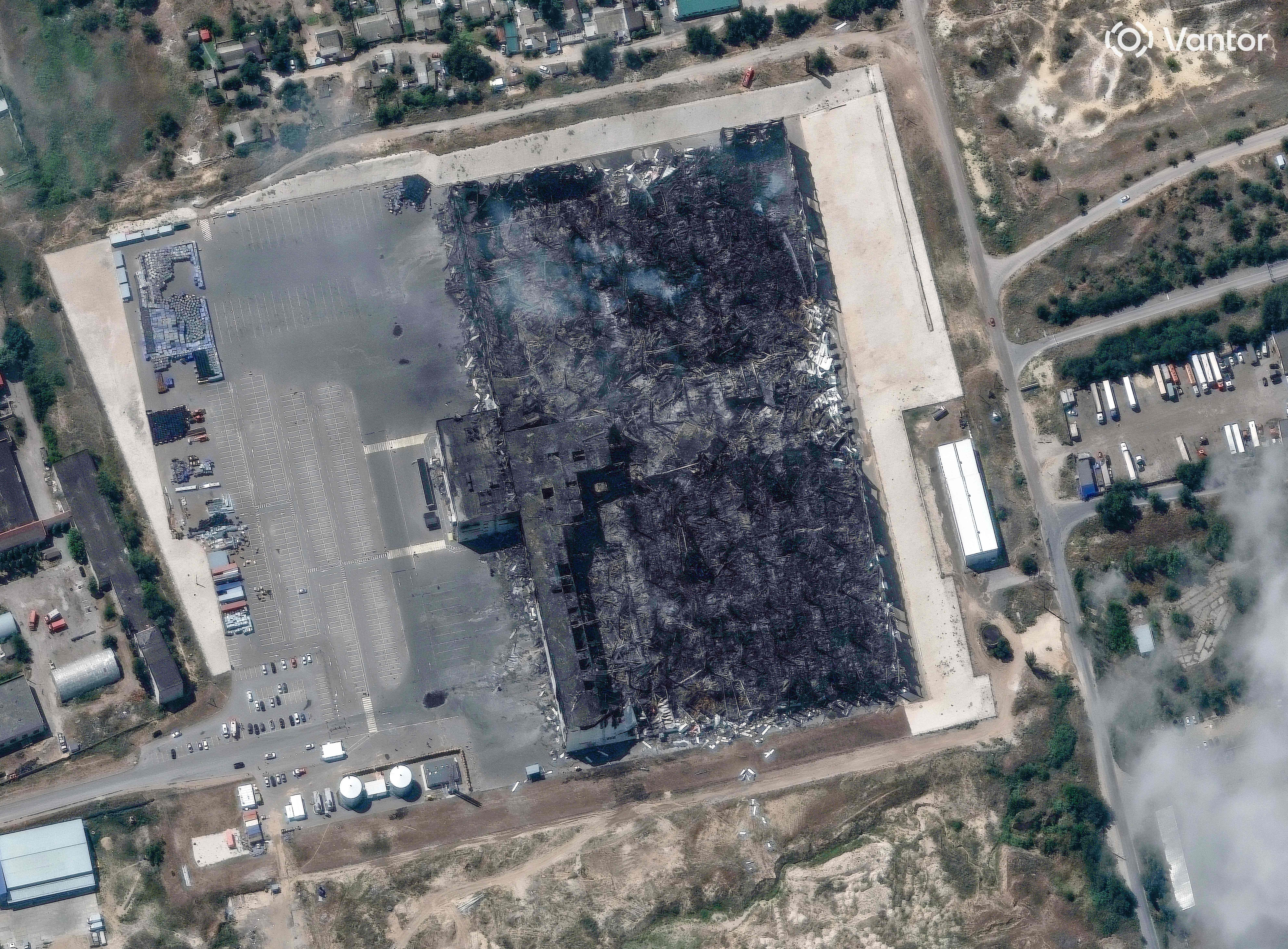 Satellitenbild des ausgebrannten "Wildberries"-Lagerhauses mit rußgeschwärztem Dach und umliegenden Parkflächen.