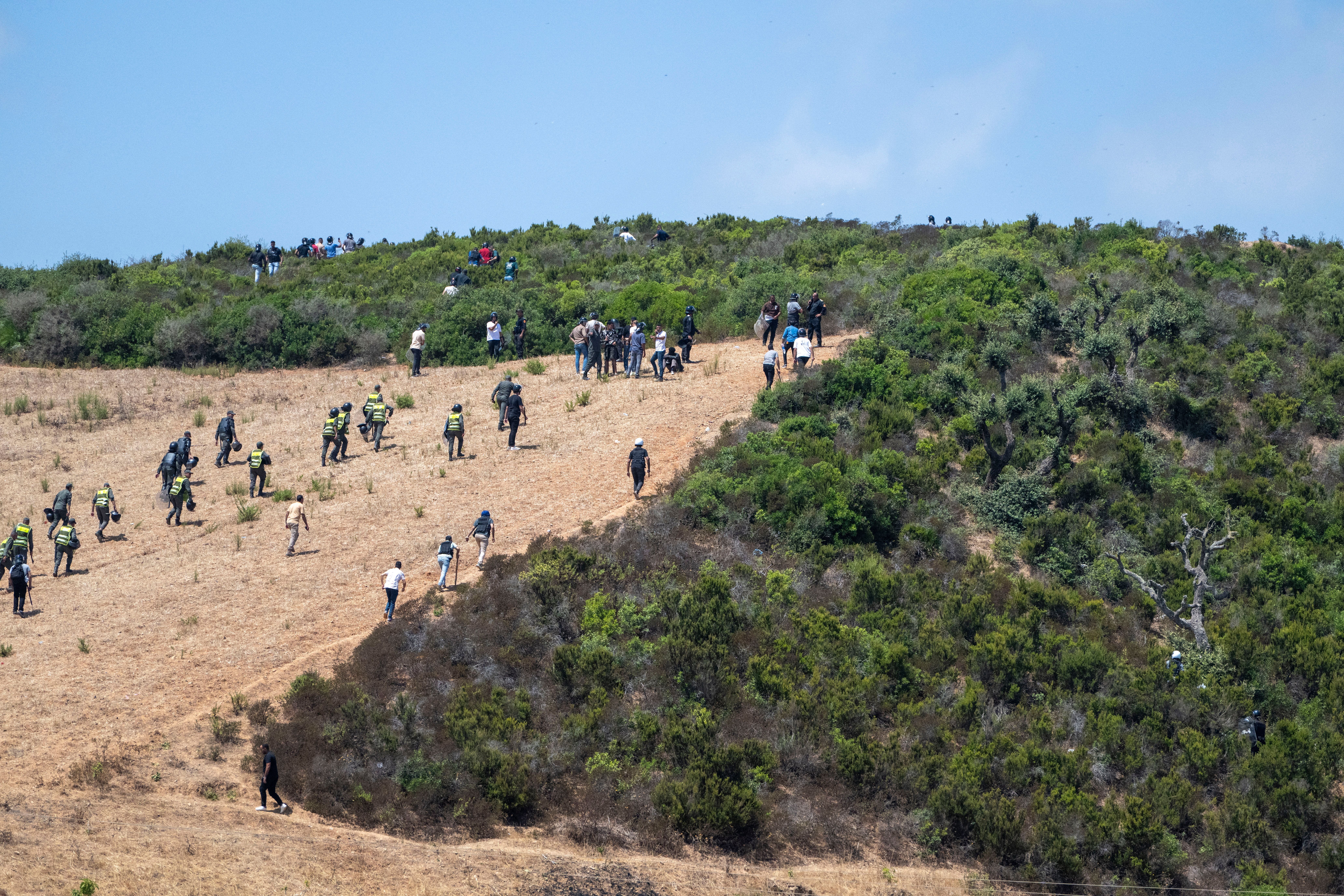 Migranten aus Subsahara-Afrika und dem Sudan versammeln sich nahe Fnideq (Castillejos), Marokko, bei dem Versuch, in die spanische Stadt Ceuta zu gelangen, 15. August 2026. Marokkanischen Sicherheitsquellen zufolge fanden die Versuche des Grenzübertritts in einem Berggebiet am Rande von Castillejos, südwestlich von Ceuta, statt.