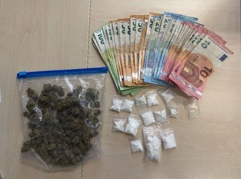 Ein Beutel mit Drogen, mehrere Tütchen mit weißem Pulver und viele Euro-Geldscheine auf einem Tisch.