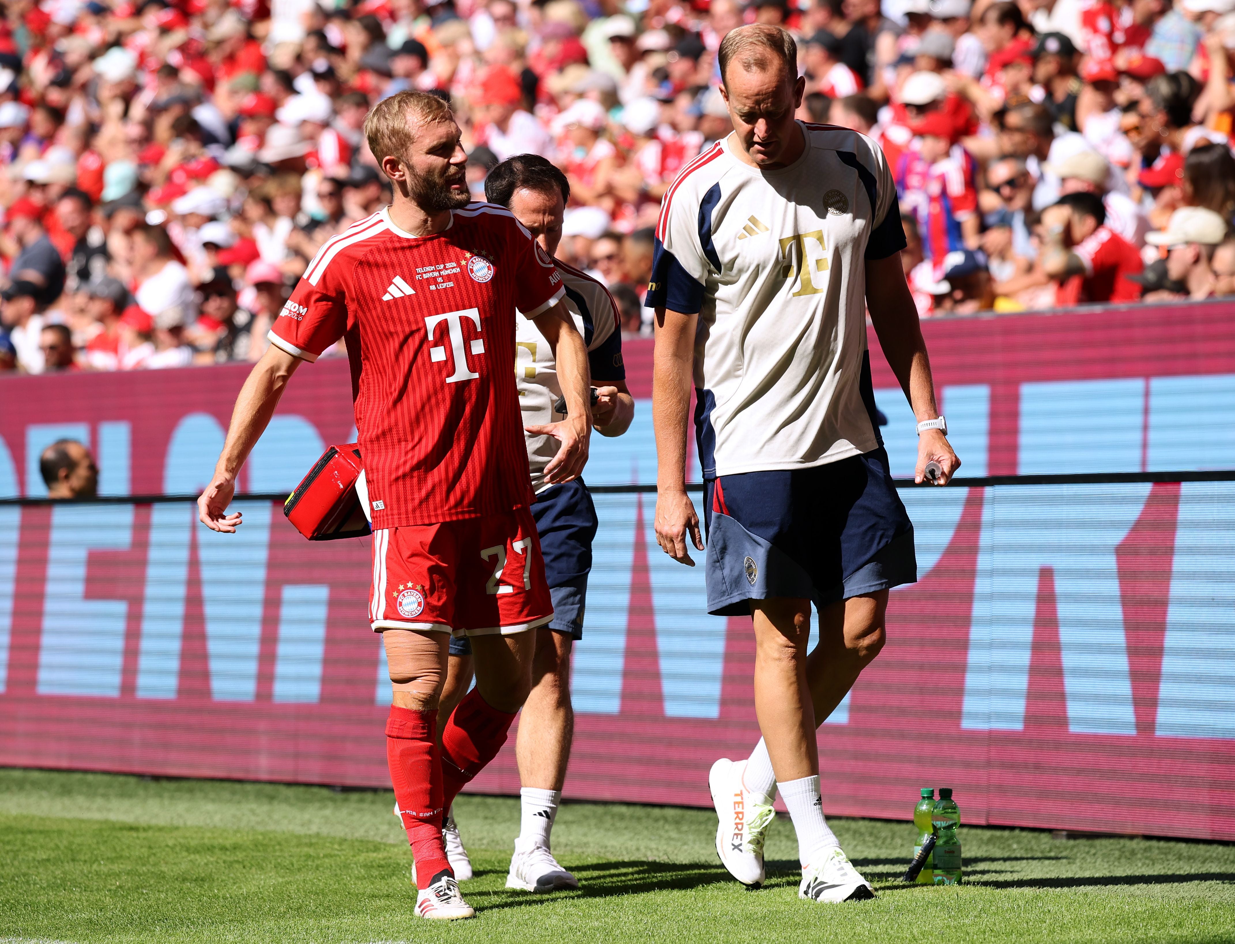 Ein Bayern-München-Spieler verlässt mit medizinischem Personal verletzt das Spielfeld.