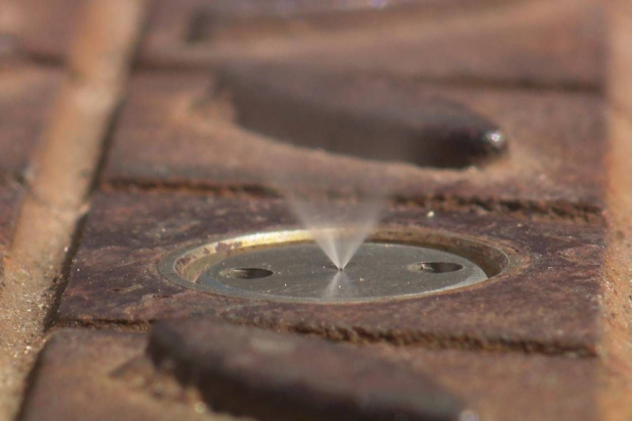 Eine Sprühnebelanlage am Boden des Domplatzes St. Pölten versprüht feinen Wassernebel.