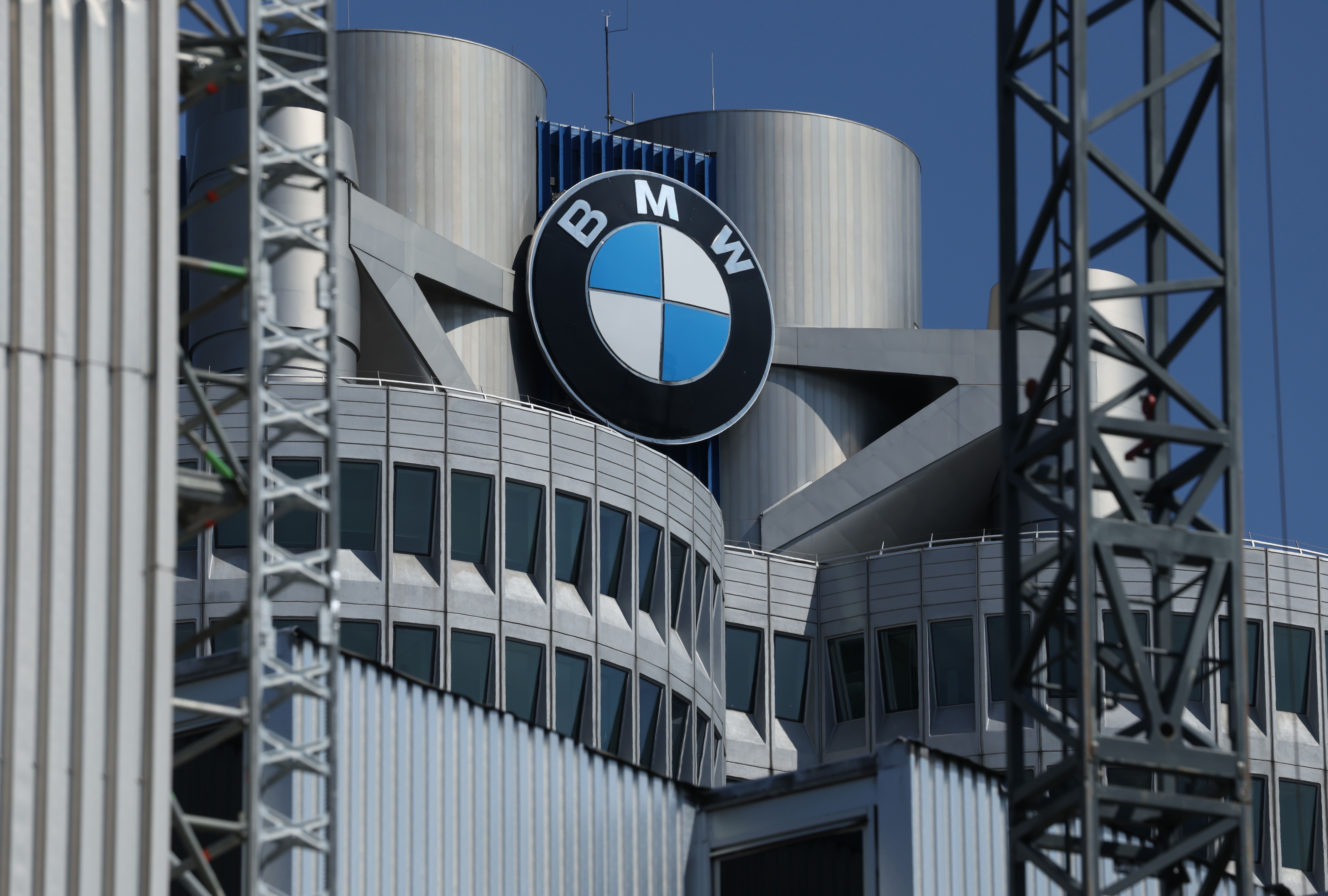 BMW Firmenzentrale mit großem BMW-Logo an der Fassade in München bei blauem Himmel.