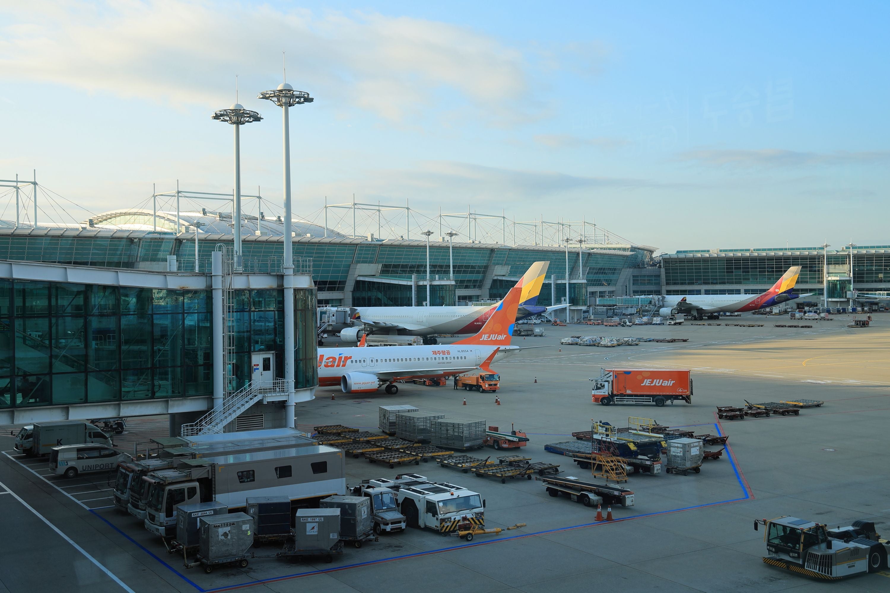 Flugzeuge stehen am Terminal des Incheon International Airport in Seoul bei Tageslicht.