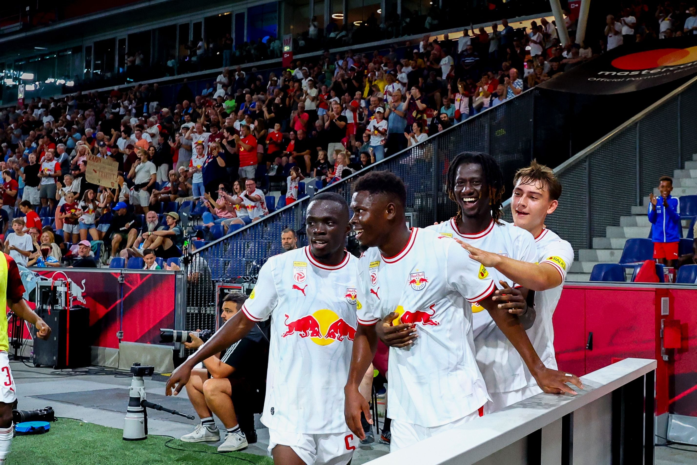 Vier Spieler von Red Bull Salzburg jubeln zusammen nach einem Tor im Stadion.
