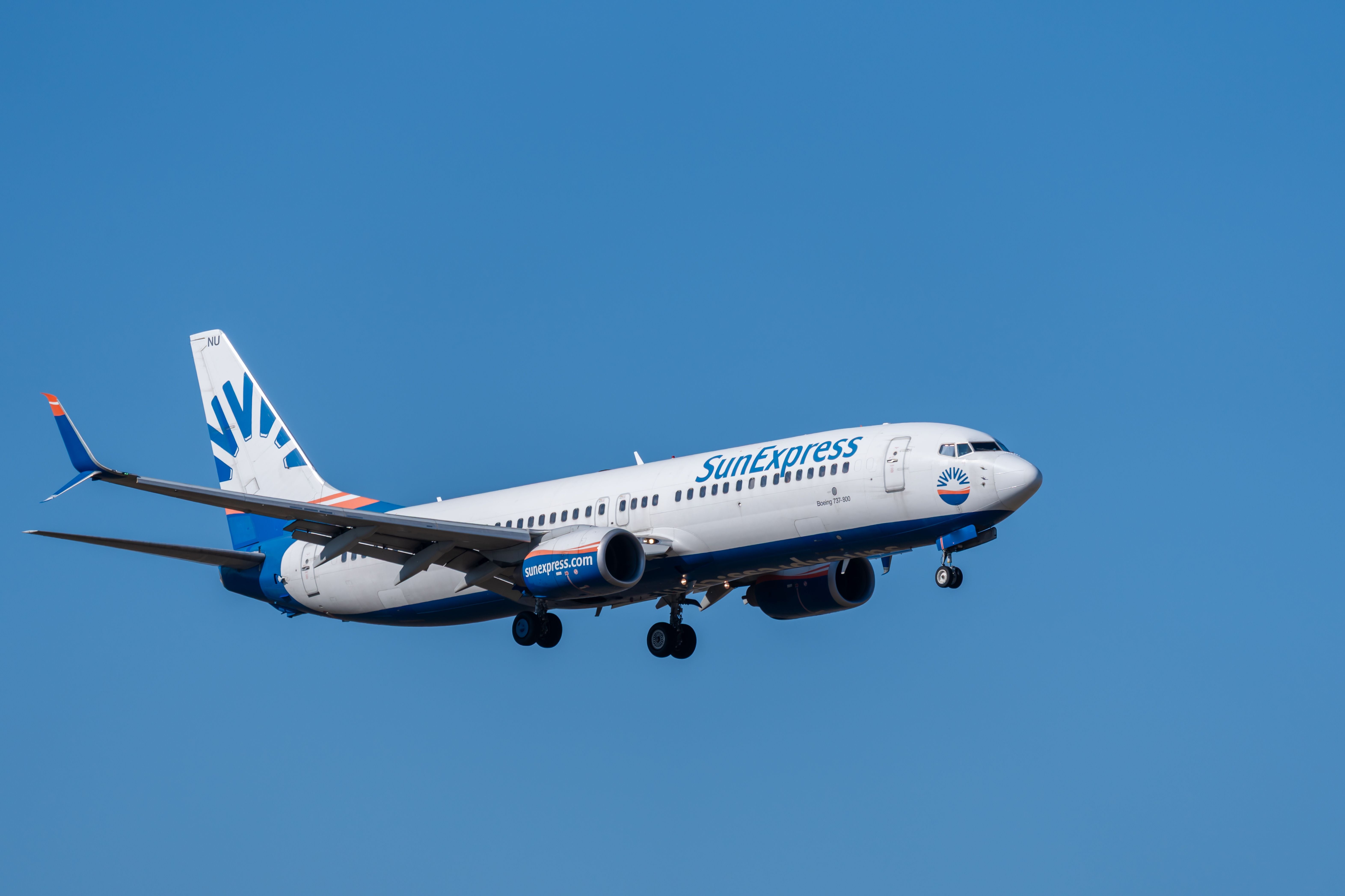 SunExpress Boeing 737 im Landeanflug vor blauem Himmel am Flughafen Berlin Schönefeld.