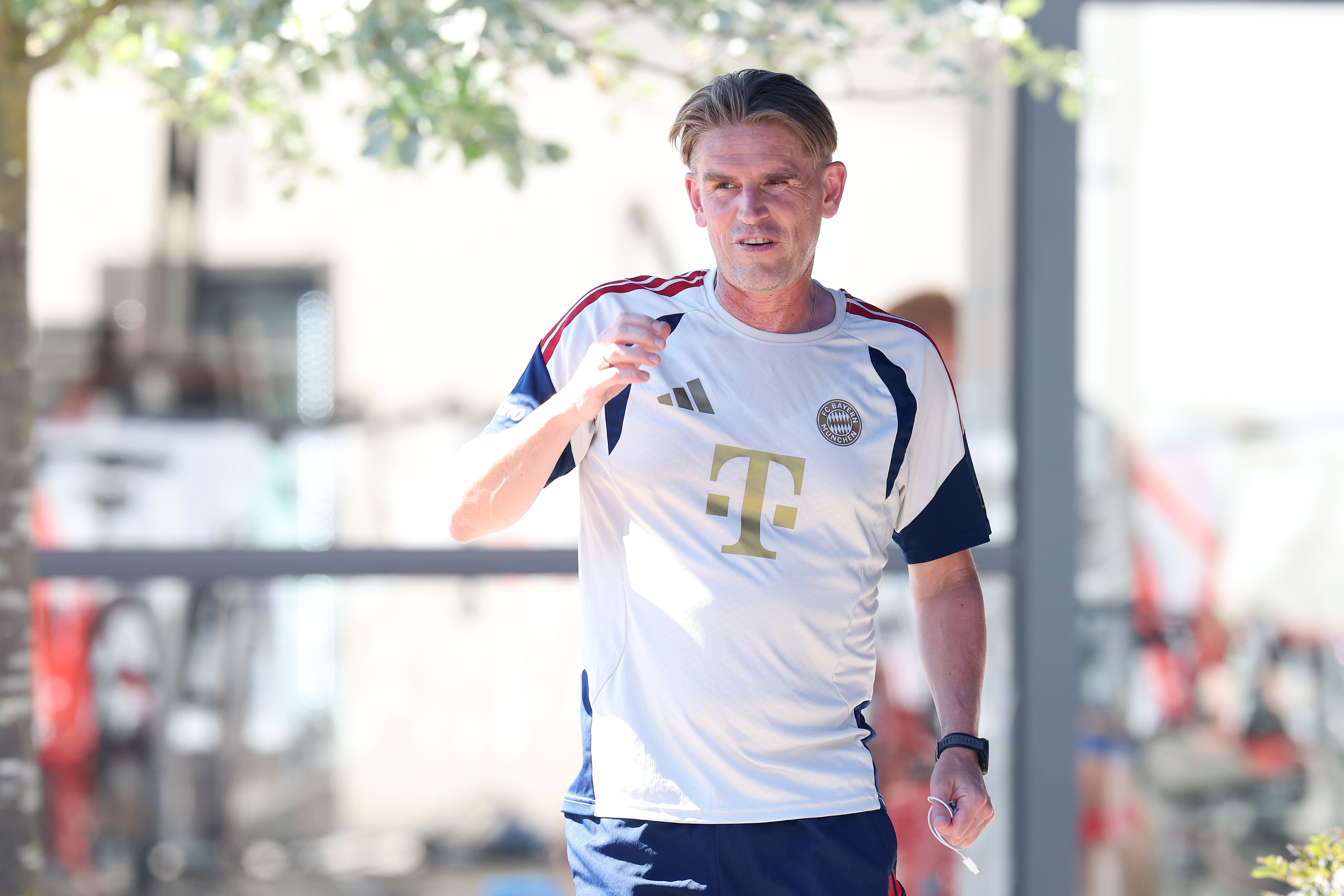 Ein Mann im FC Bayern München Trainingsoutfit läuft im Freien während eines Trainingslagers.