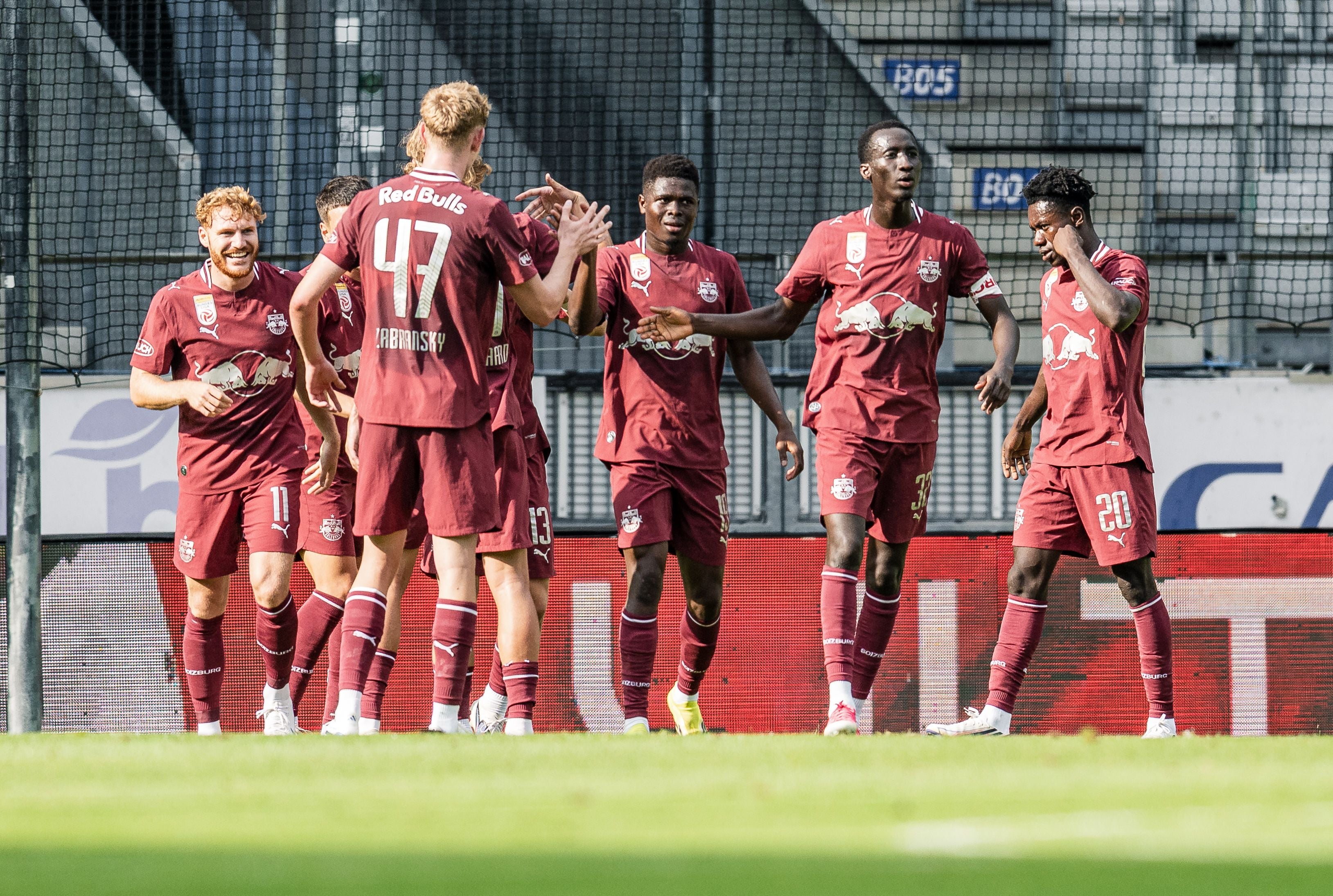 Spieler des FC Red Bull Salzburg jubeln im Stadion nach einem Tor während eines Fußballspiels.