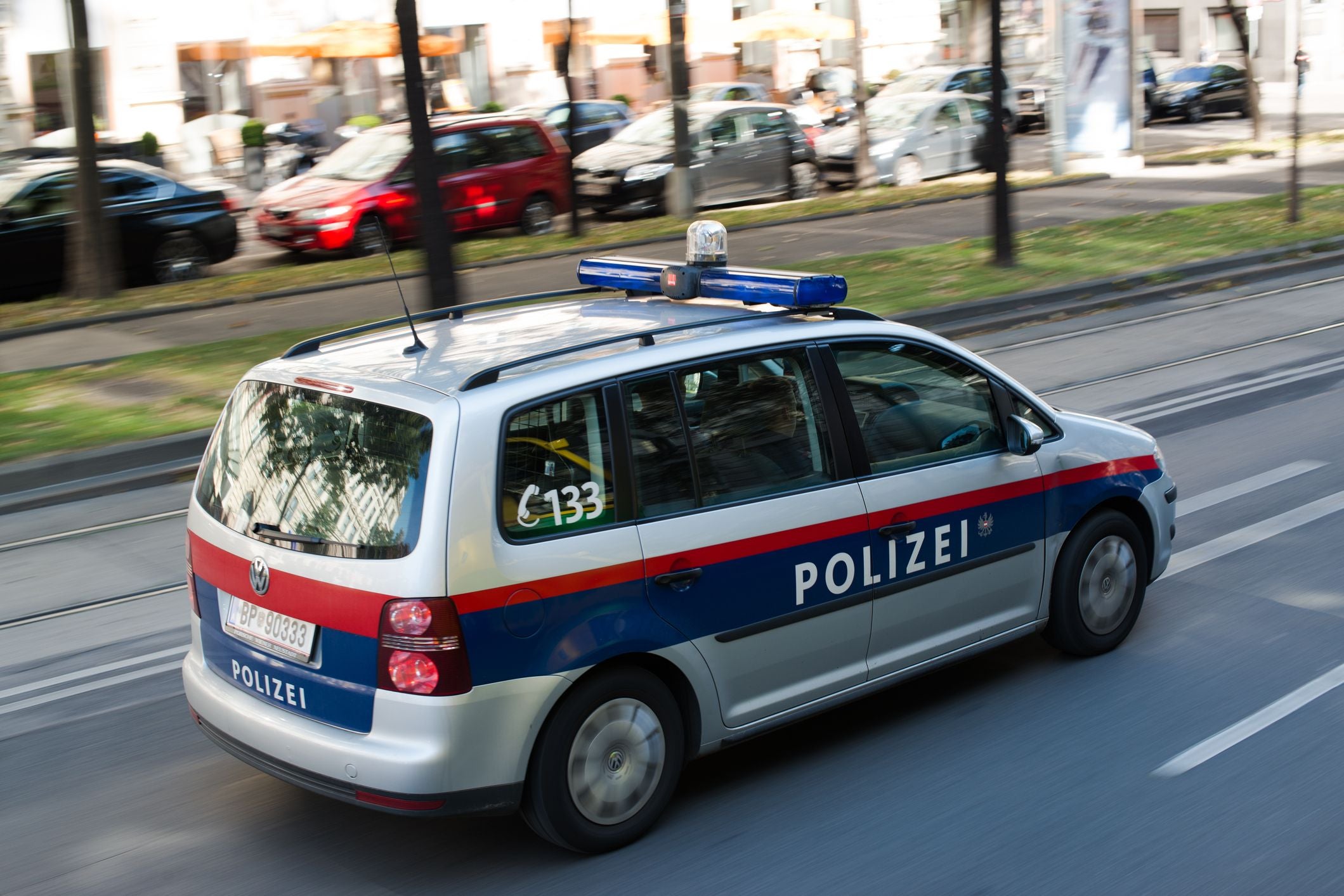 Ein Polizeiauto der österreichischen Bundespolizei fährt auf einer Straße in Wien.