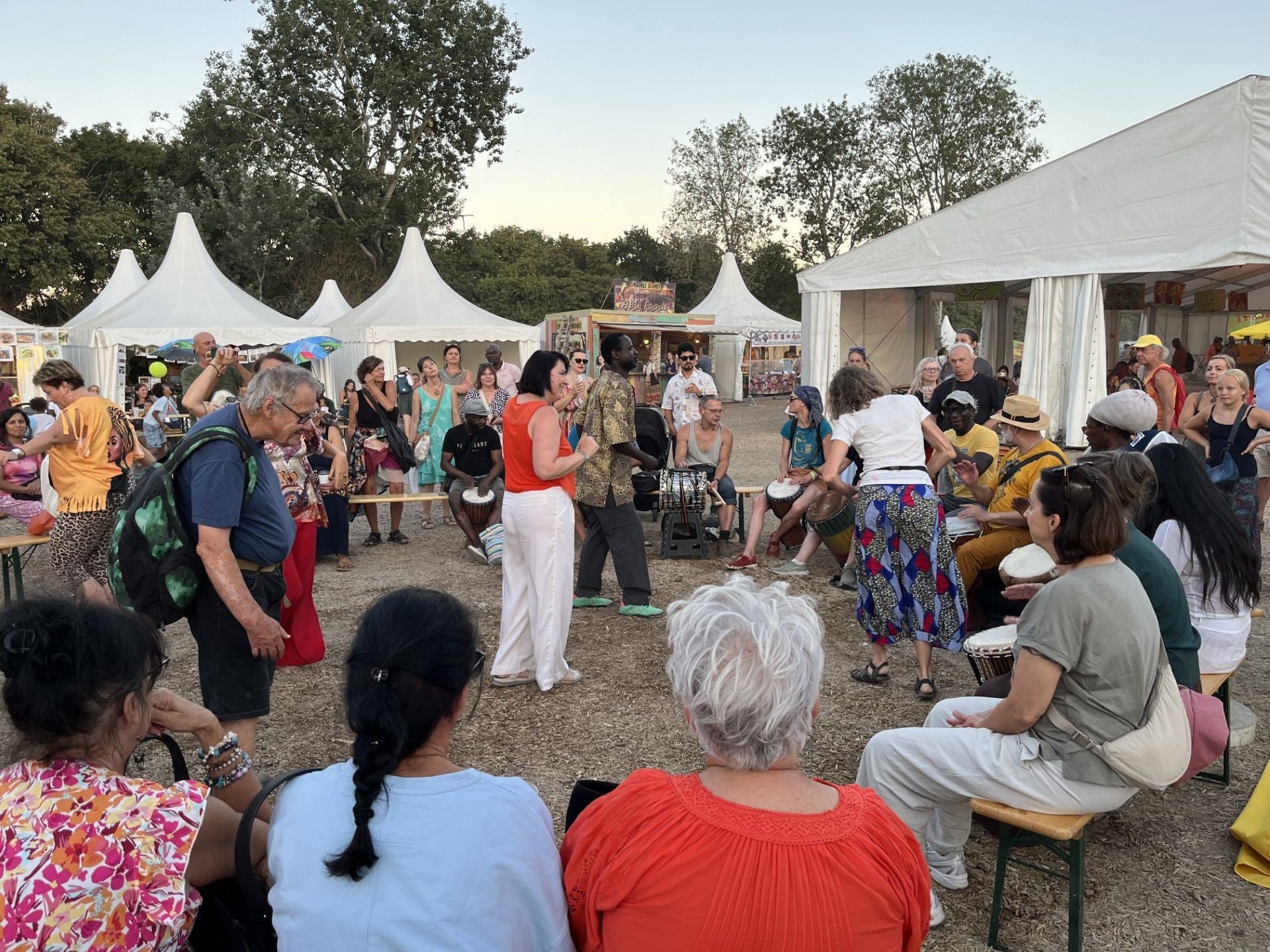 Gruppe von Menschen trommelt und feiert gemeinsam auf dem Afrika Tage Festival im Freien.