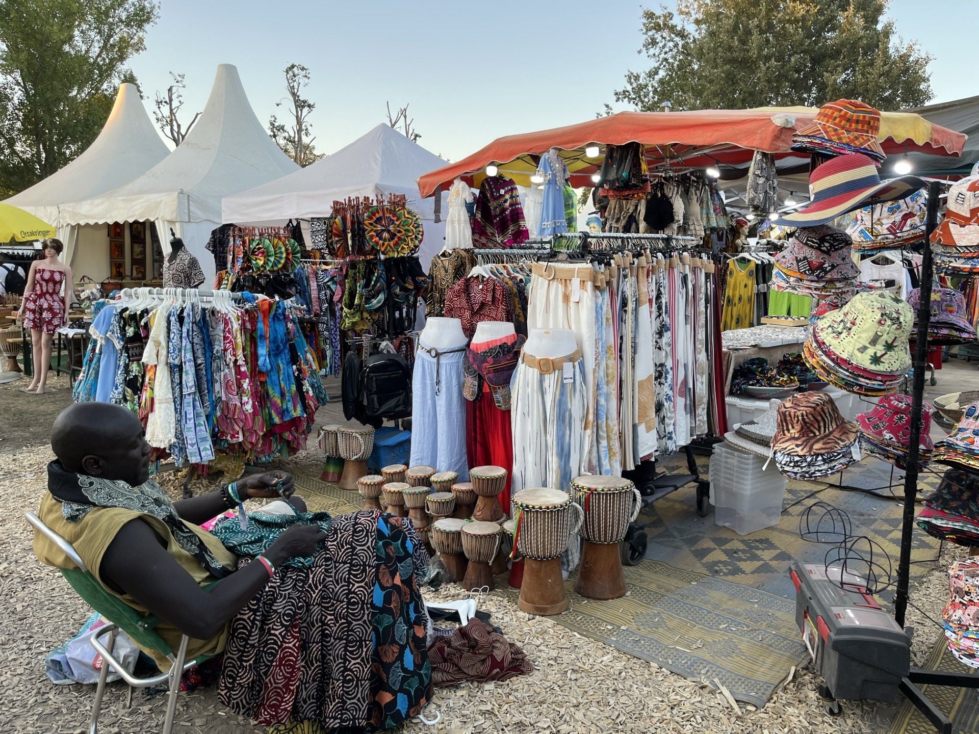 Bunter Marktstand bei den Afrika Tagen mit afrikanischen Kleidern, Trommeln und Hüten.
