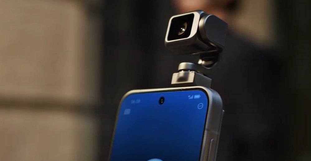 Nahaufnahme eines Smartphones mit einer kleinen Roboterkamera auf der Oberseite.