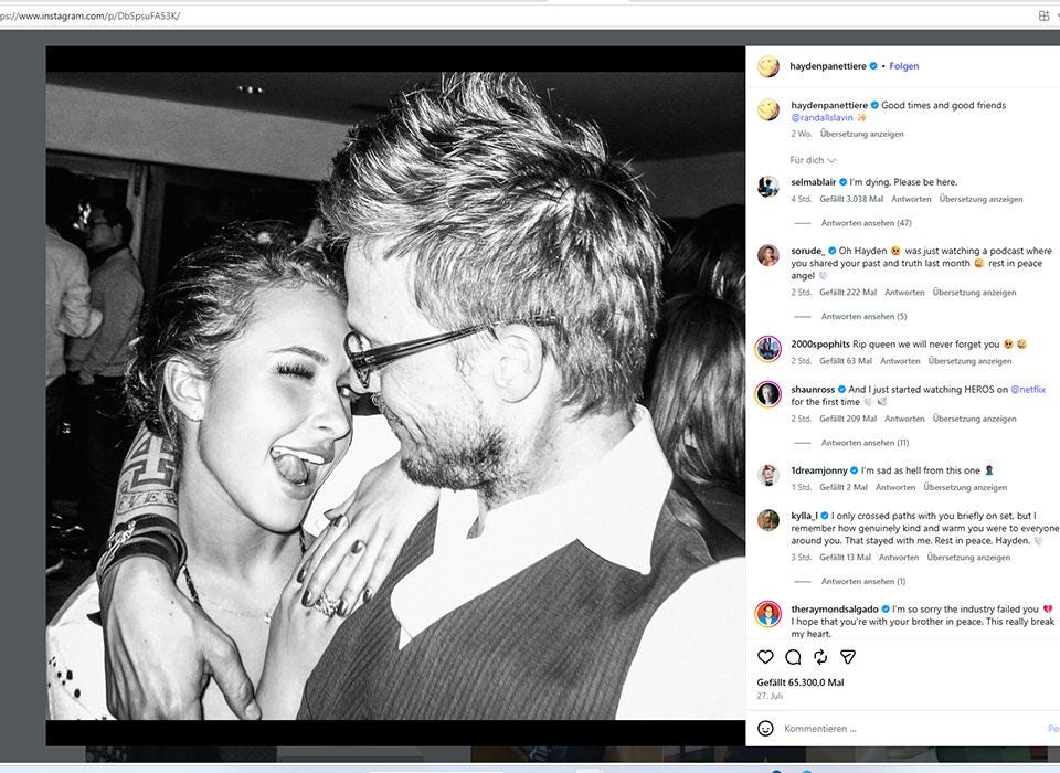 Frau und Mann umarmen sich lachend auf einer Party, schwarz-weiß Foto.