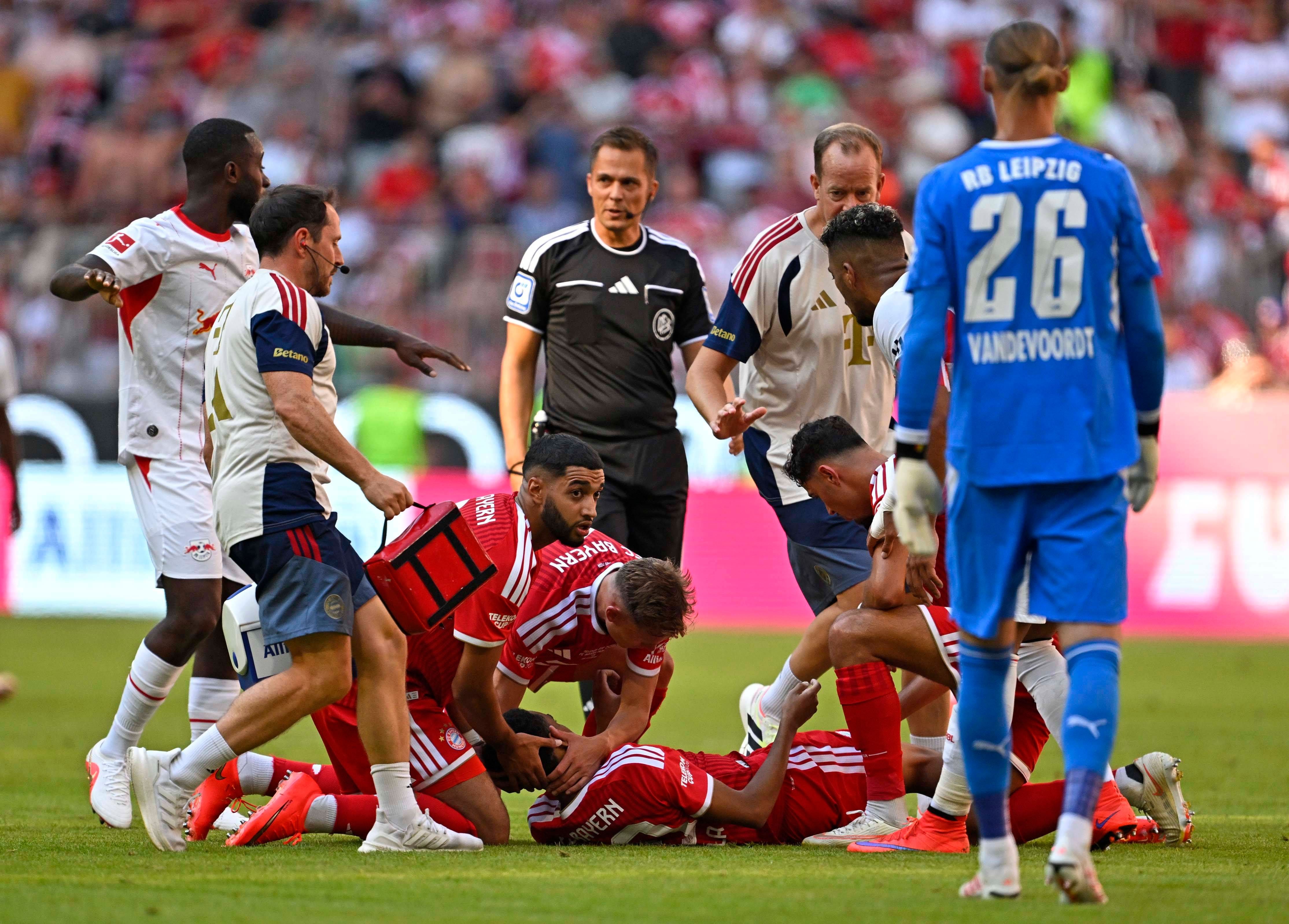 Jamal Musiala liegt verletzt am Boden, Saibari und Kimmich leisten ihm Hilfe, Ärzte und Spieler um ihn.