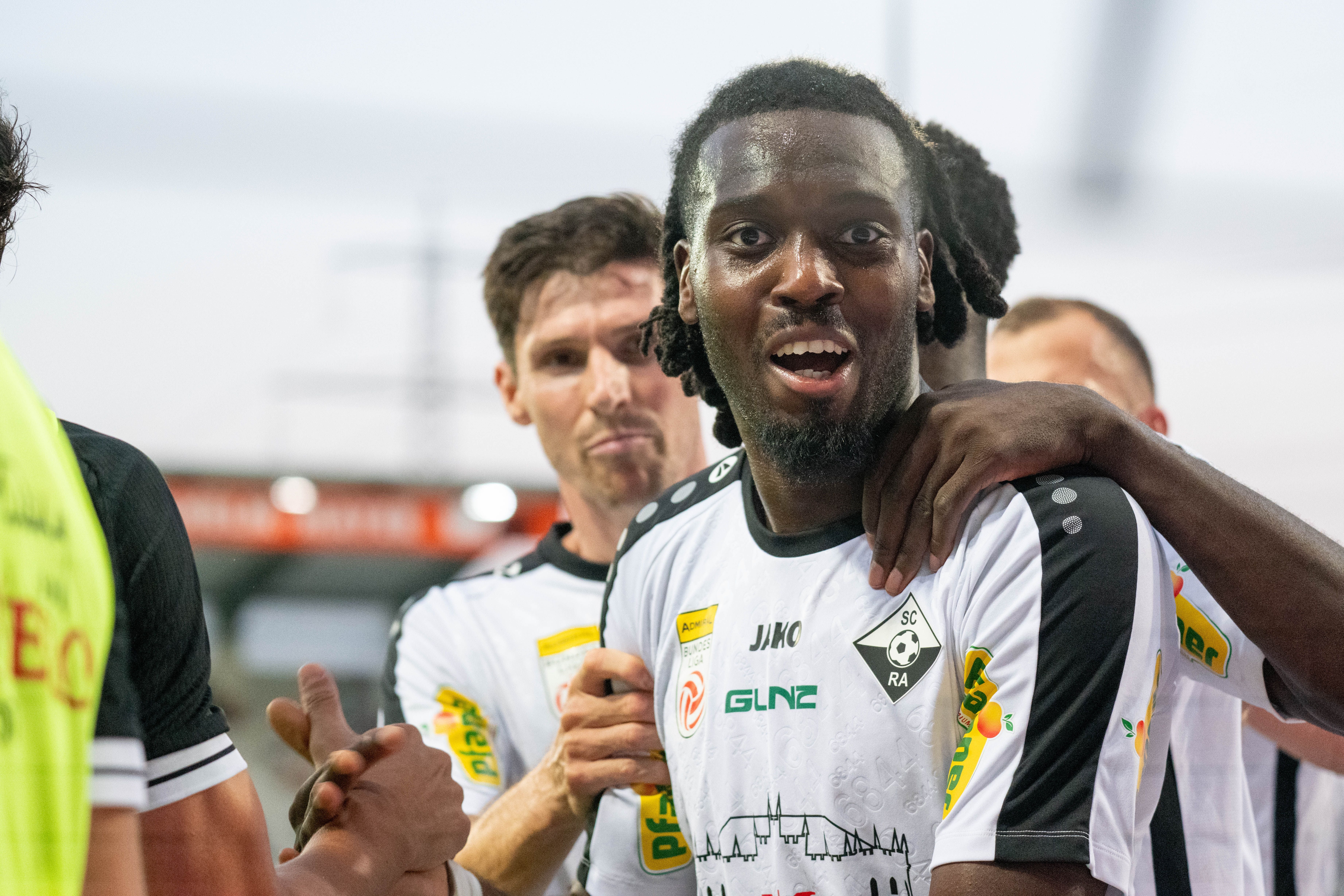 Mehrere Fußballspieler von SCR Altach jubeln gemeinsam auf dem Spielfeld.