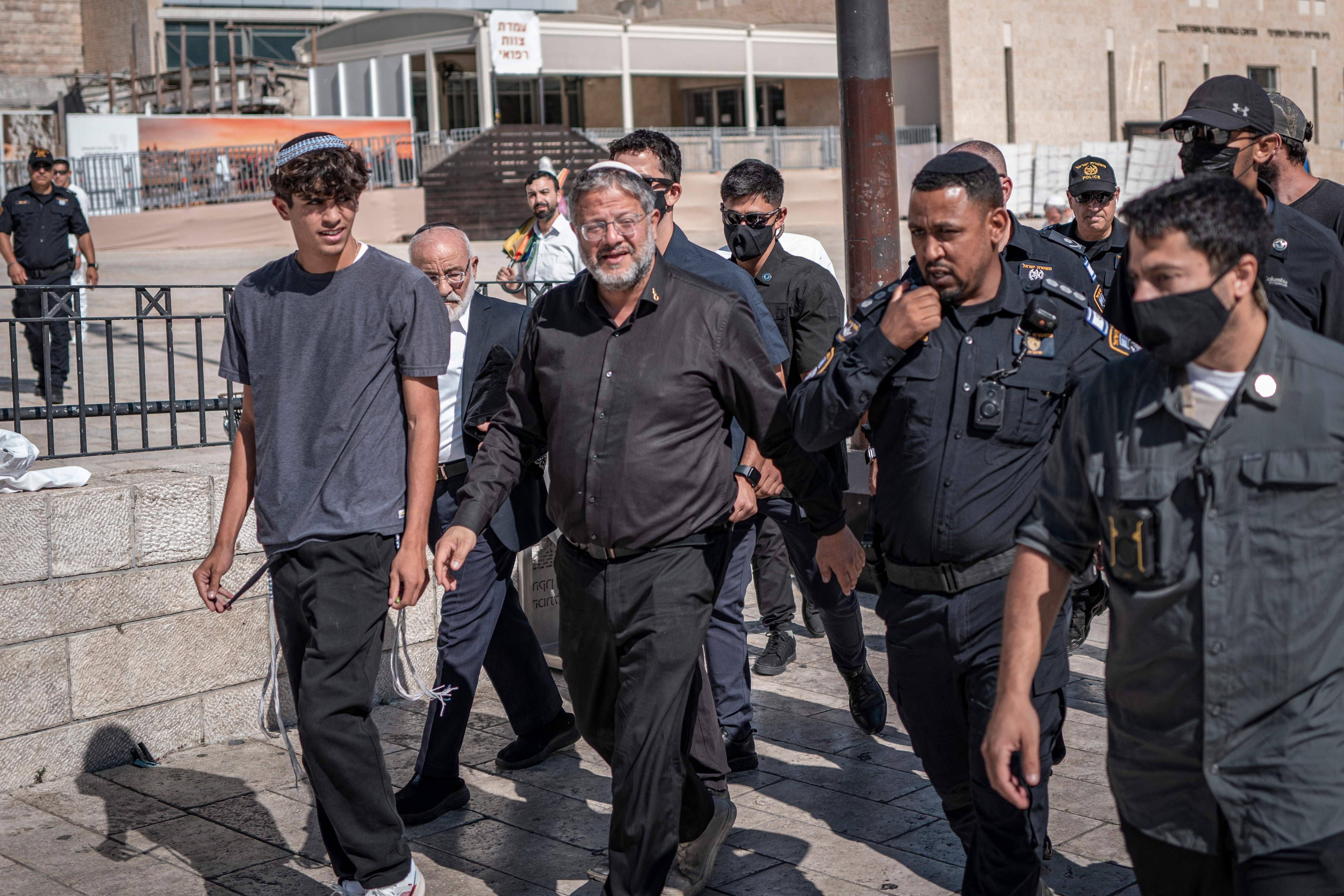 Mehrere Männer, darunter Polizisten und Zivilisten, gehen gemeinsam auf einem Platz in Jerusalem.