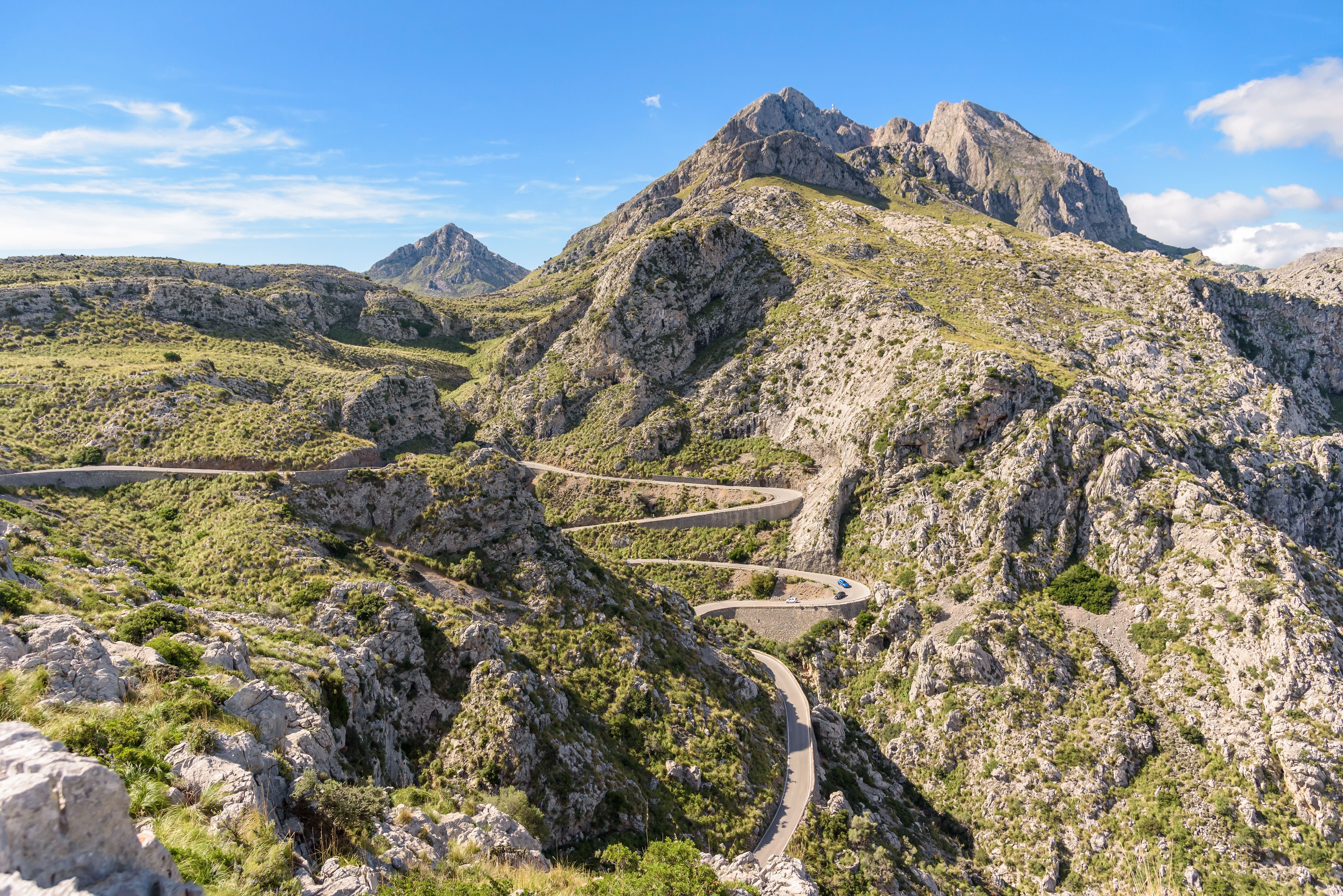 Serpentinenstraße schlängelt sich durch die Berge der Serra de Tramuntana vor dem Gipfel Puig Major.