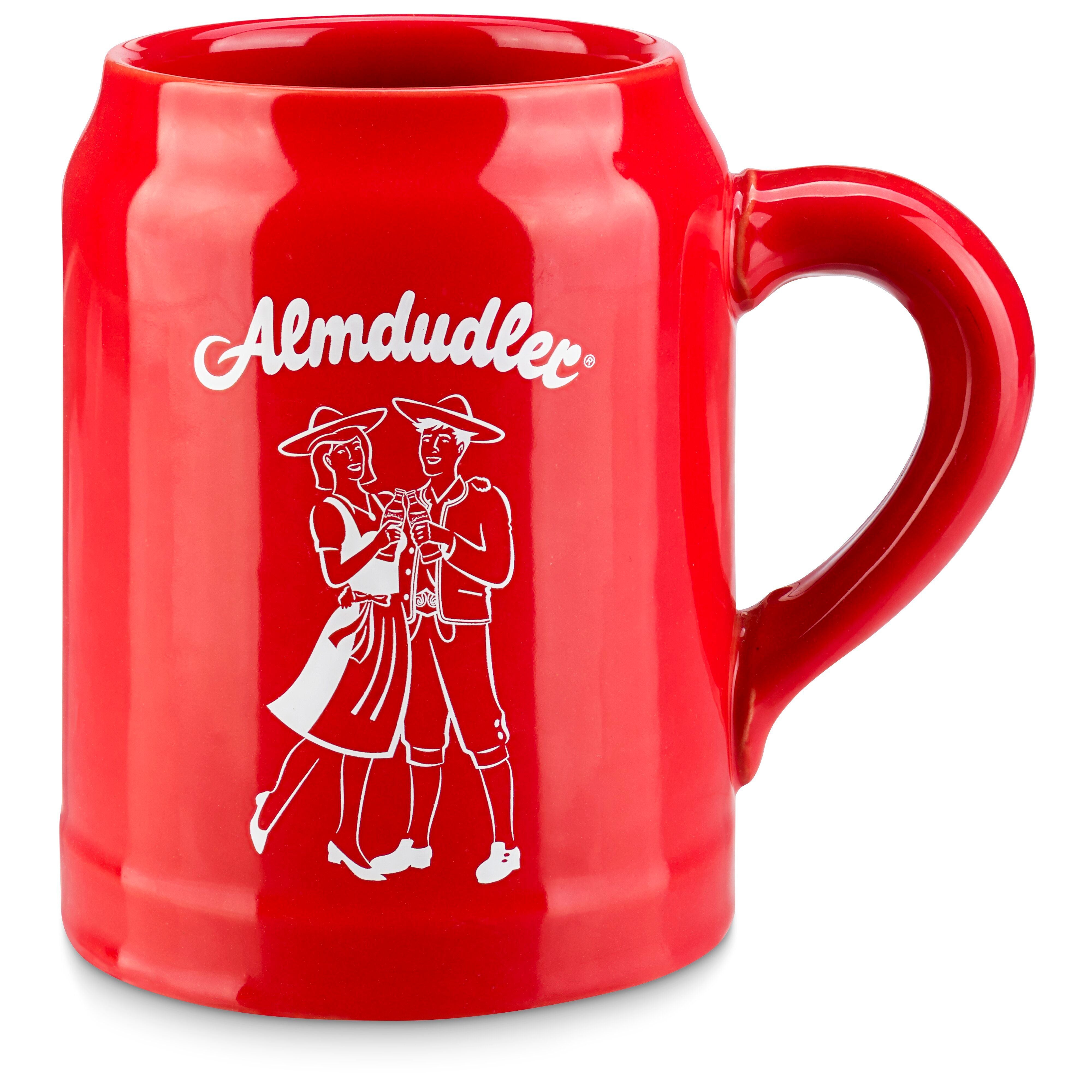Roter Almdudler-Tonkrug mit weißem Logo und Trachtenpaar-Aufdruck.