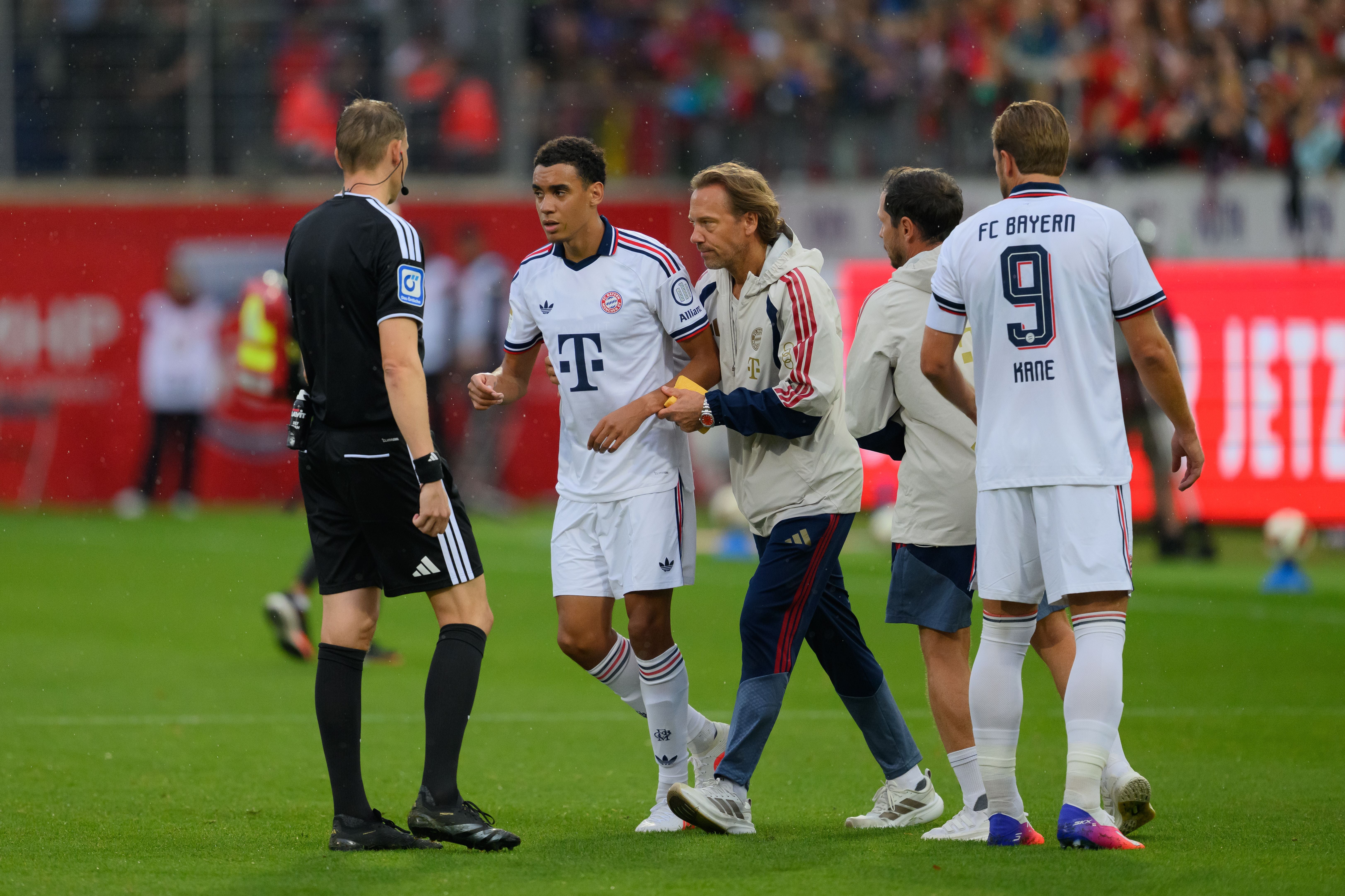 Jamal Musiala verlässt nach medizinischer Behandlung das Spielfeld beim Testspiel von Bayern München.