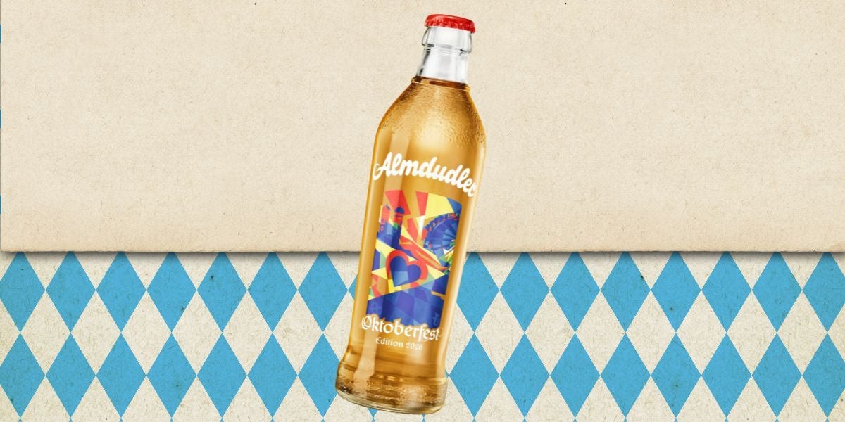 Eine Almdudler-Flasche mit Oktoberfest-Edition auf blau-weiß kariertem Hintergrund.