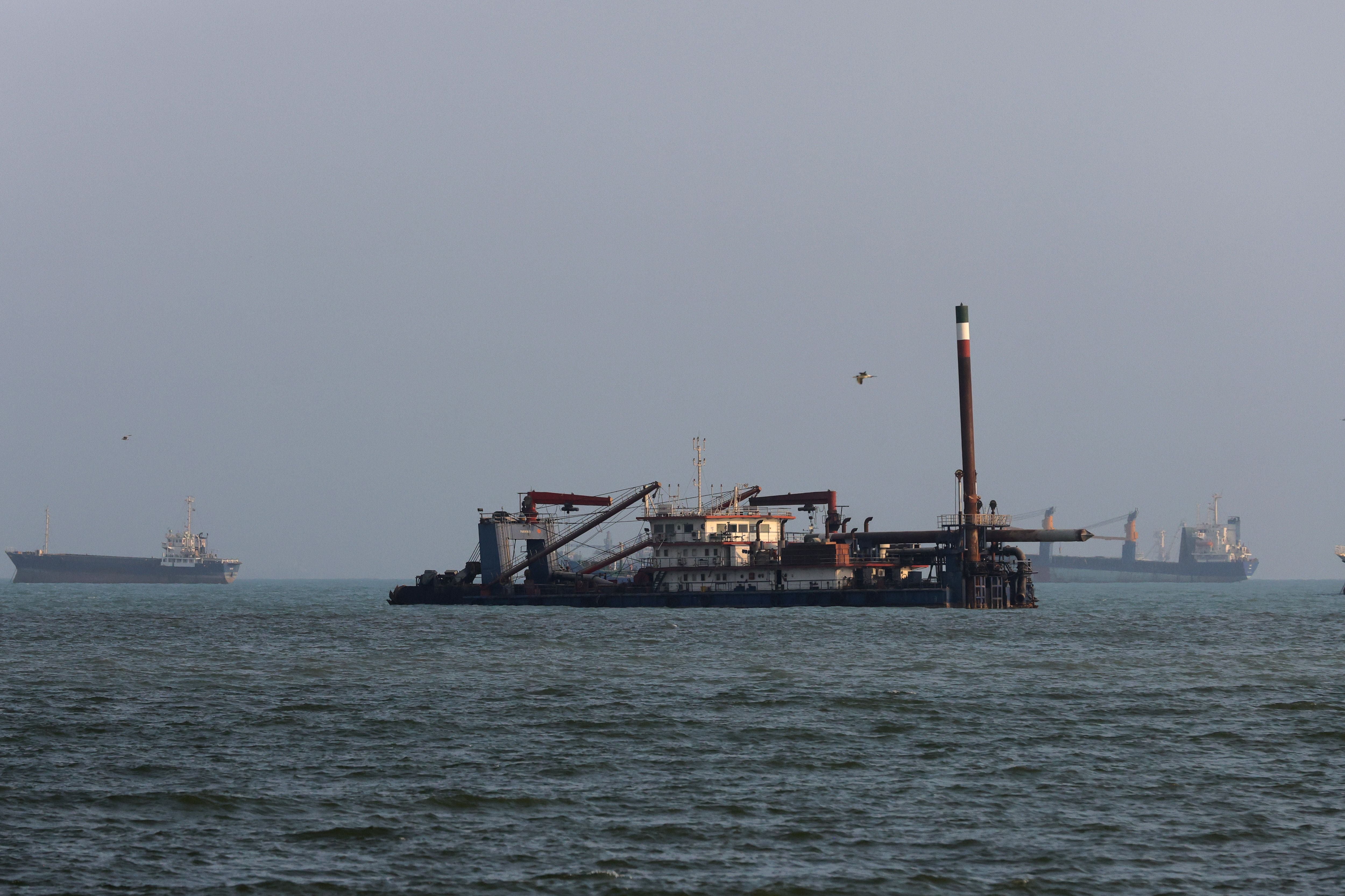 Frachtschiffe sind im Meer vor der Küste von Bandar Abbas im Dunst vor Anker zu sehen.