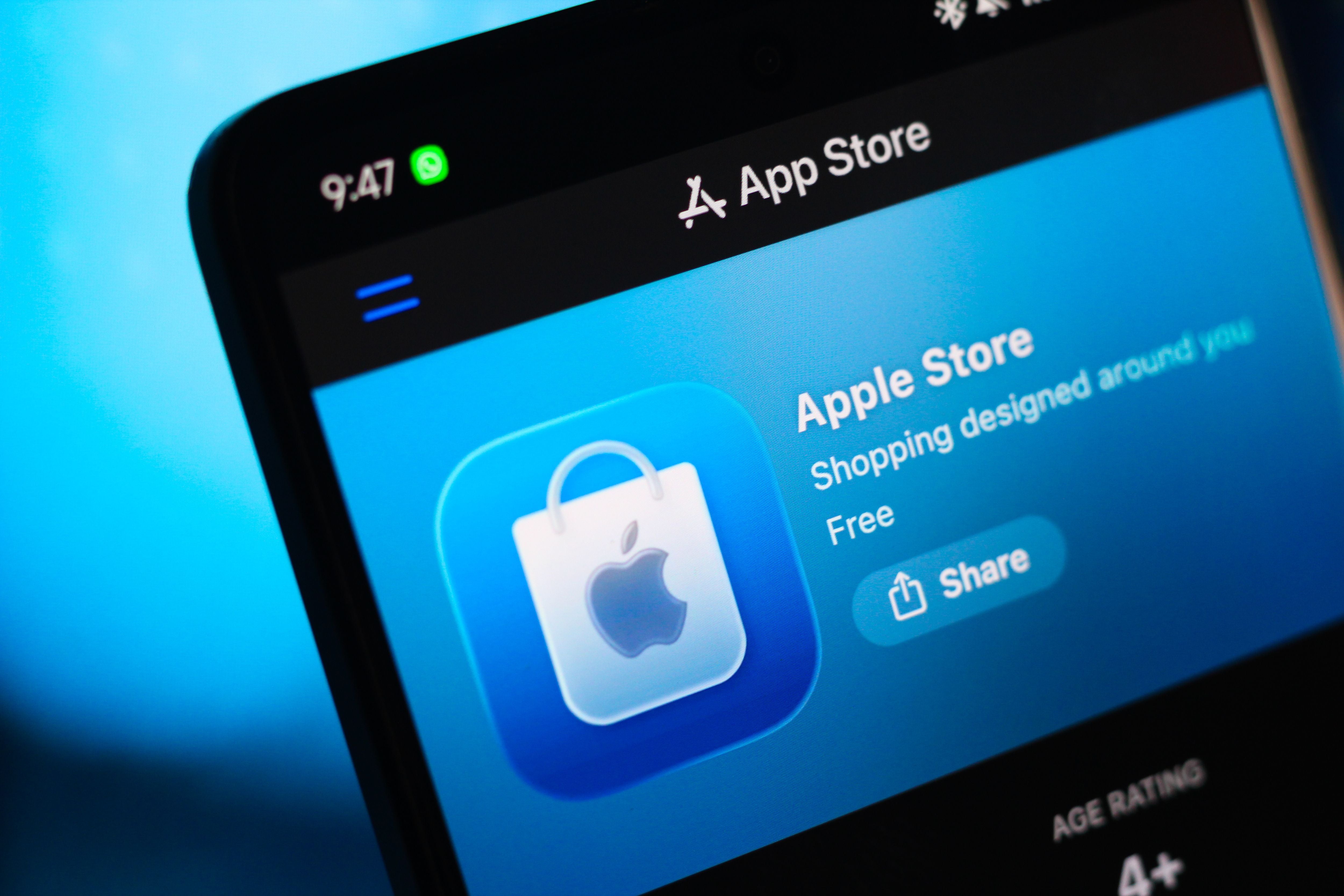Apple Store App im App Store auf einem Smartphone-Bildschirm mit blauem Hintergrund angezeigt.