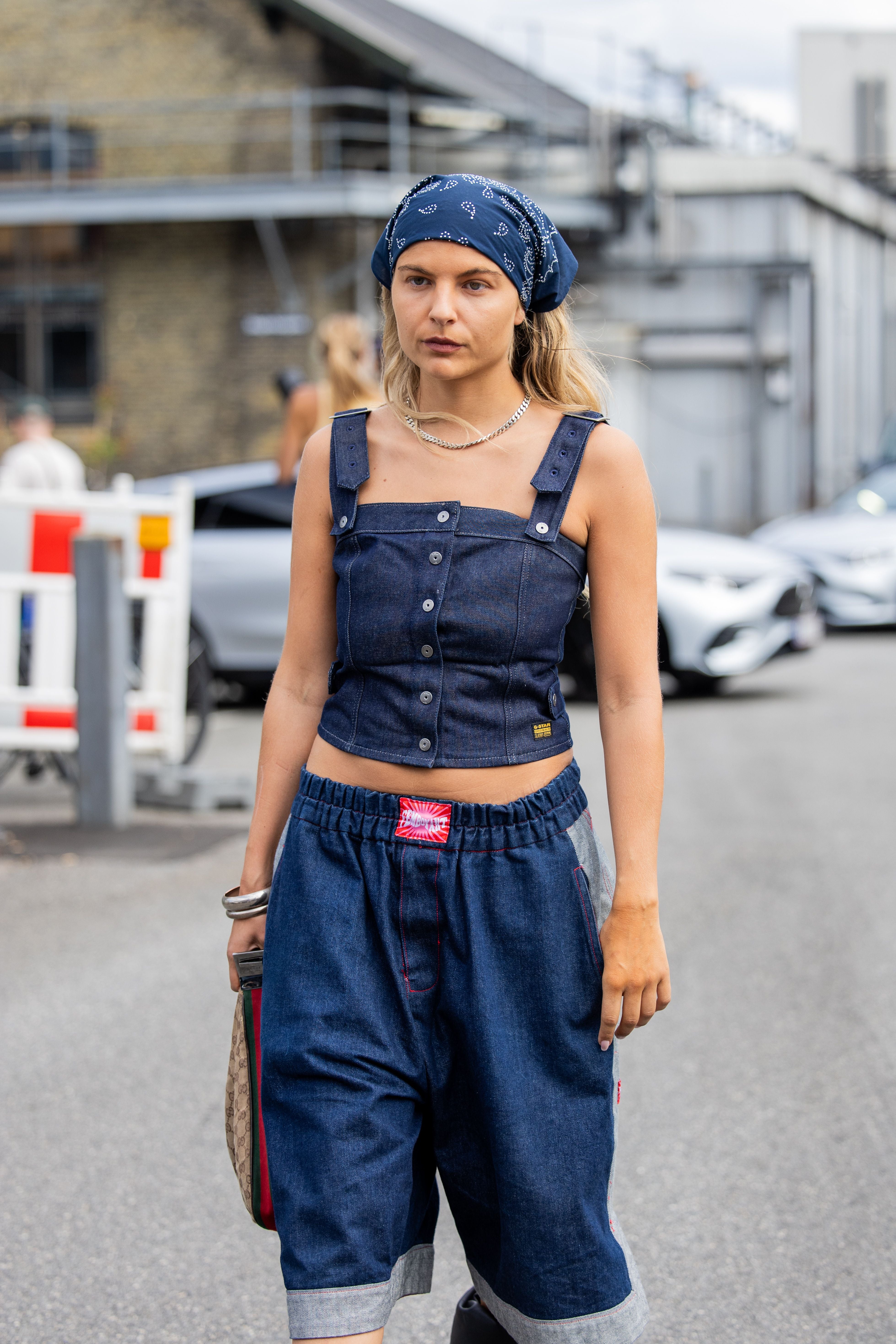 Frau mit blauem Bandana, Jeans-Top und weiten Shorts bei der Copenhagen Fashion Week.