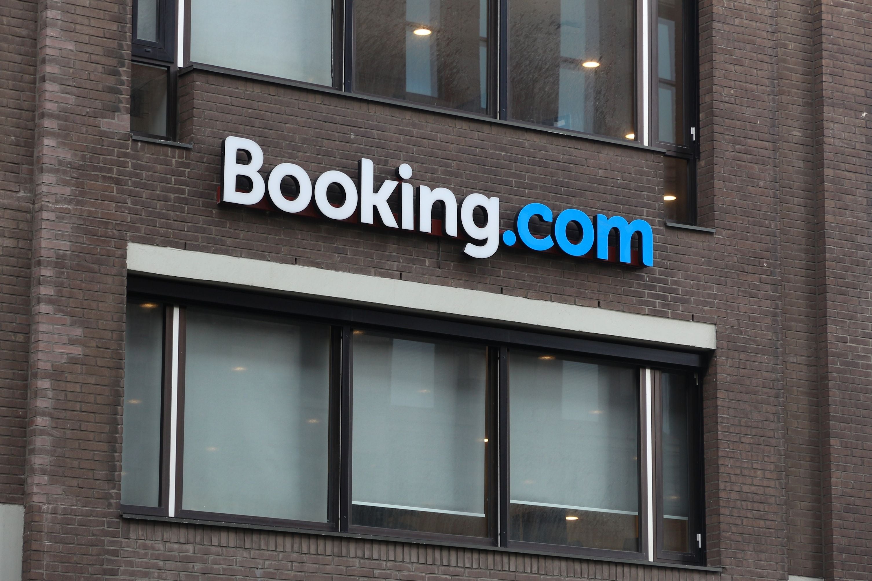 Booking.com Firmenschild an einem Backsteingebäude in Amsterdam.