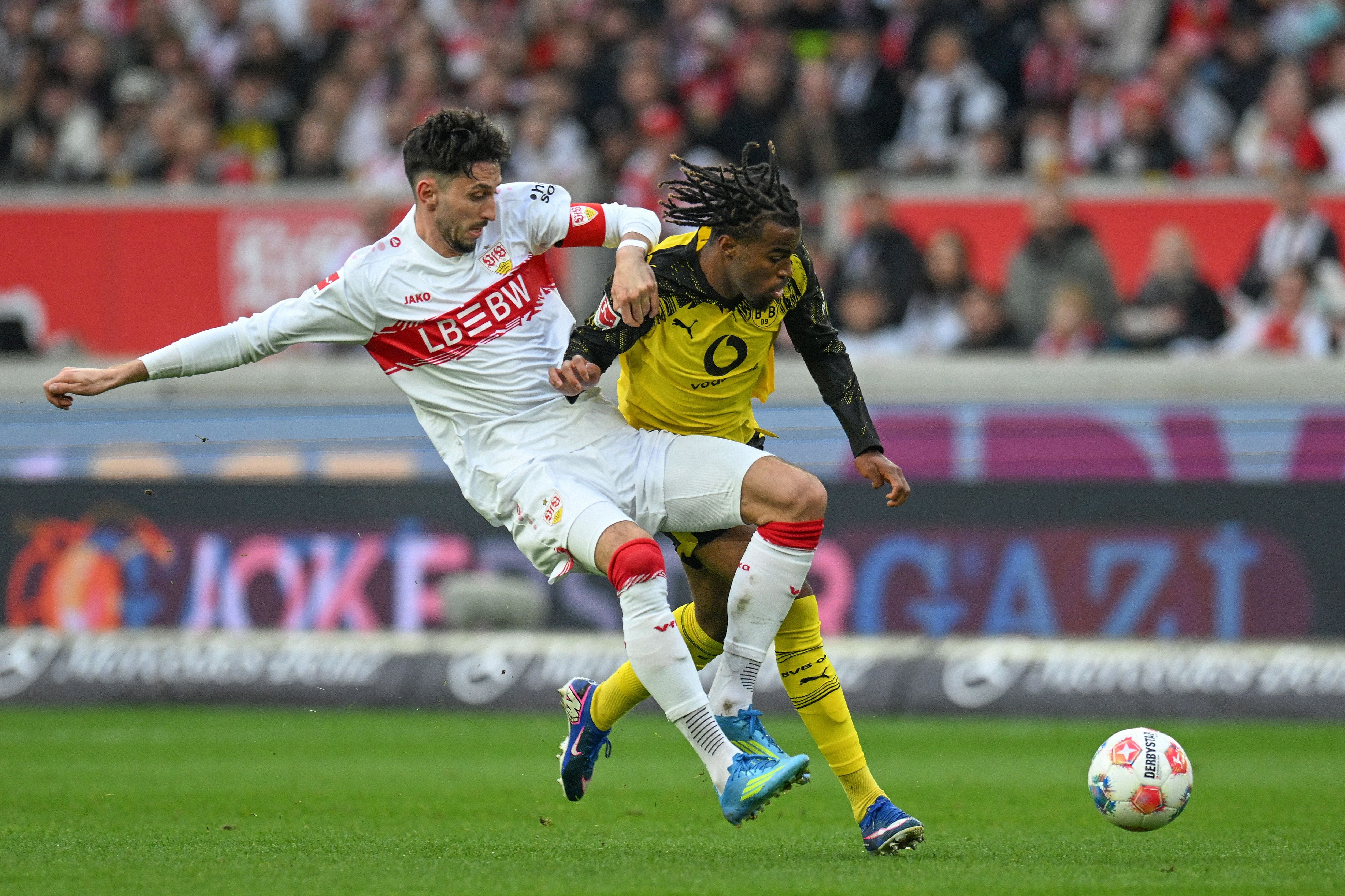 Ein Spieler von Stuttgart und ein Spieler von Dortmund kämpfen im Spiel um den Ball.