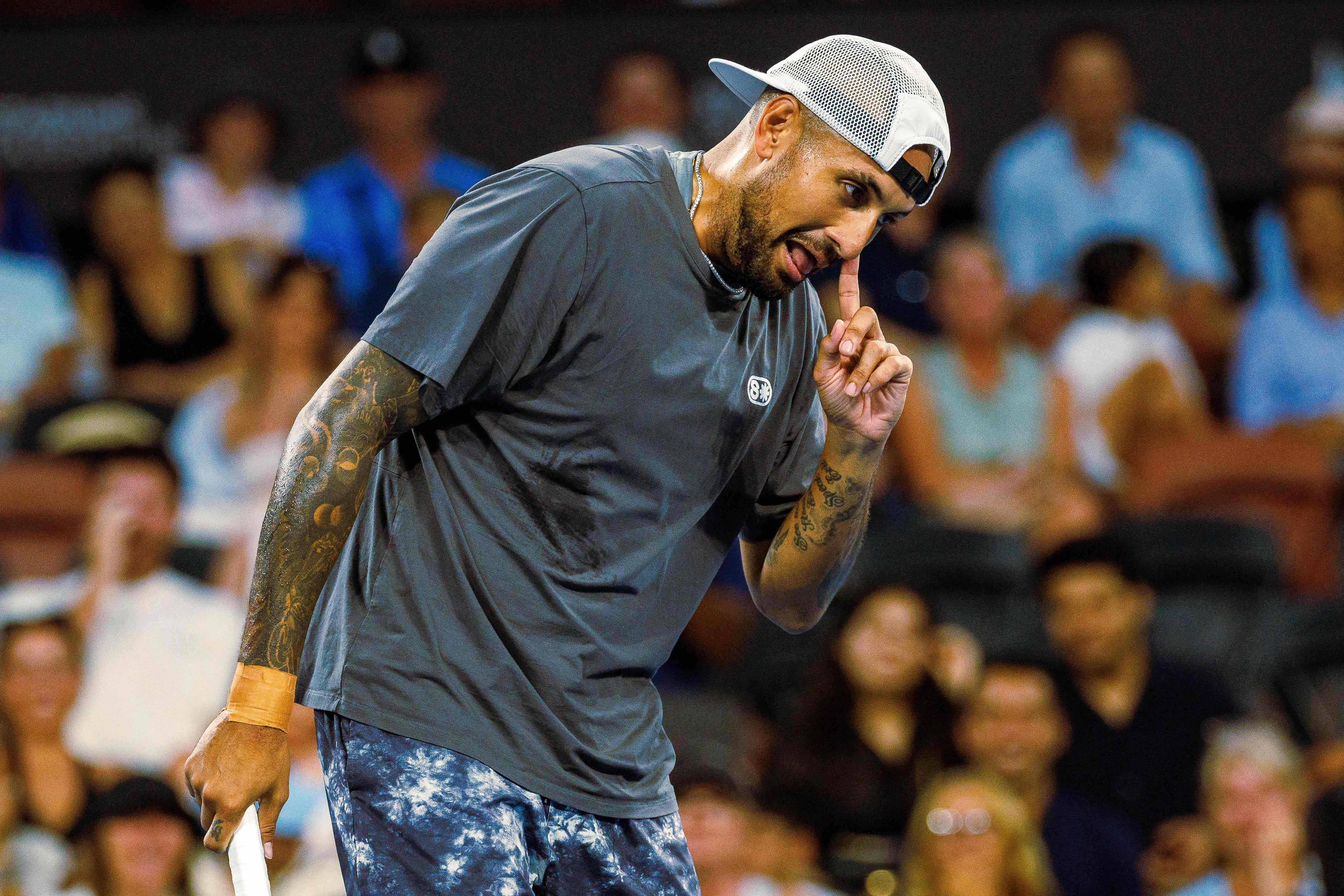 Nick Kyrgios macht eine Geste während eines Tennisspiels, Zuschauer im Hintergrund.